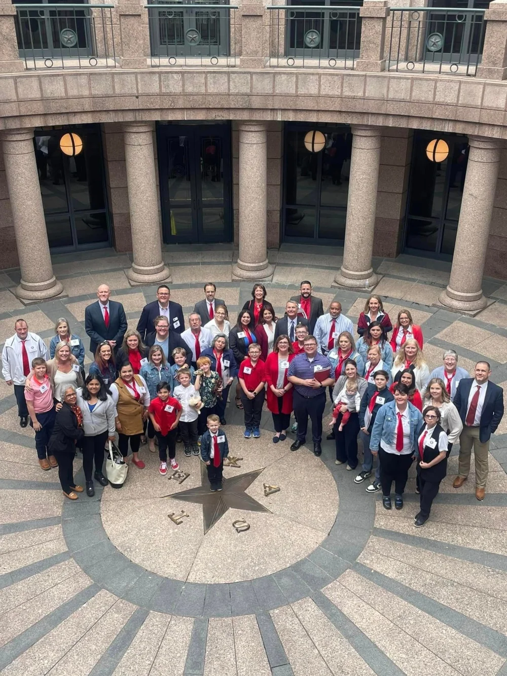 Advocates and their families photographed from above on the Texas Capitol rotunda floor