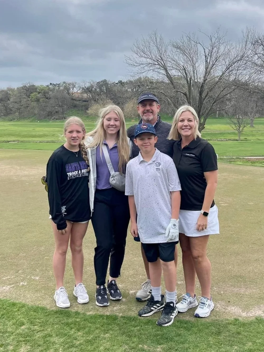 A family of five on the course at Heroes in the Hills, the youngest wearing a golf glove