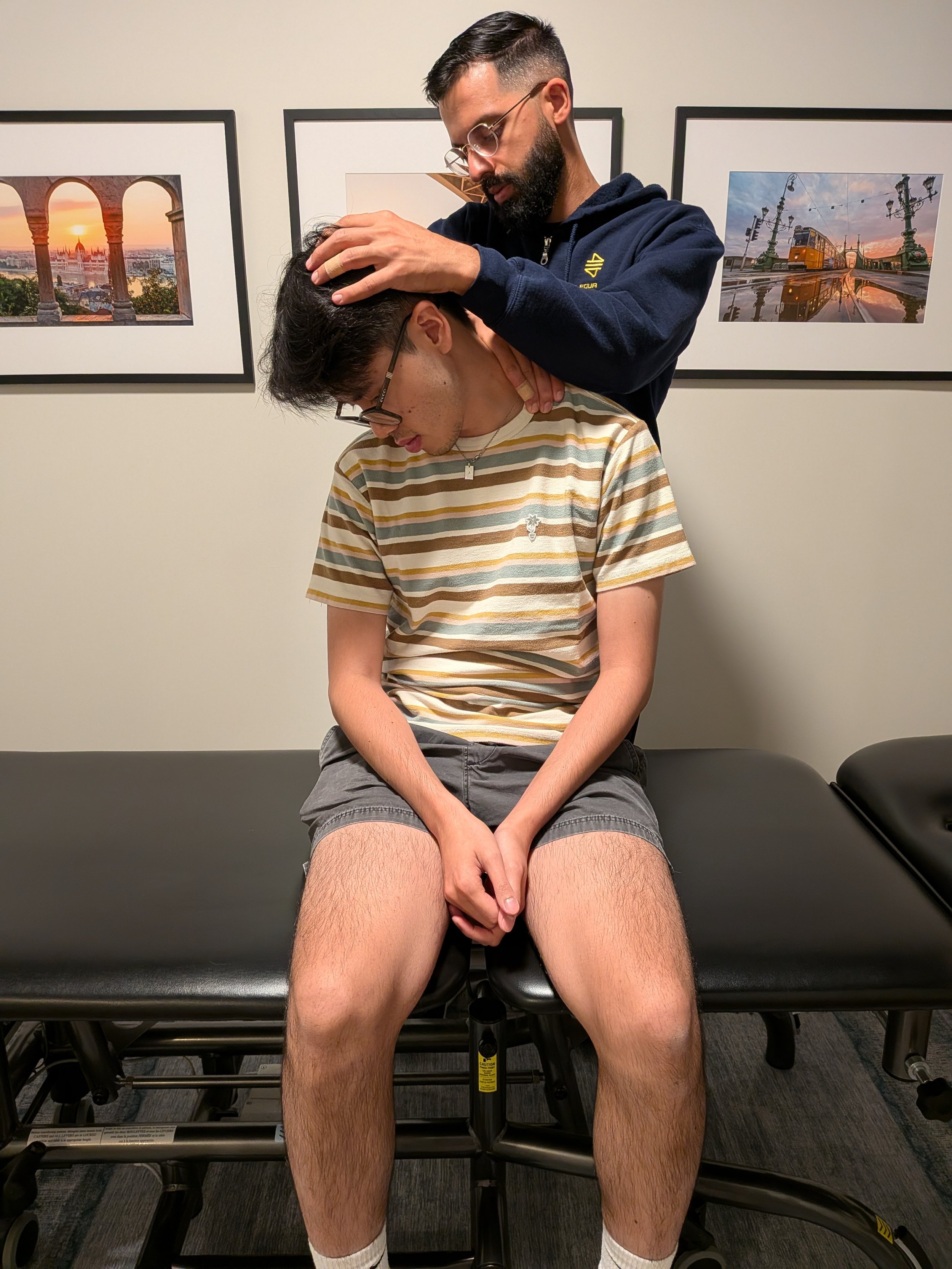 Dr. Sahib Gill assessing a patient's neck at 416 Physio