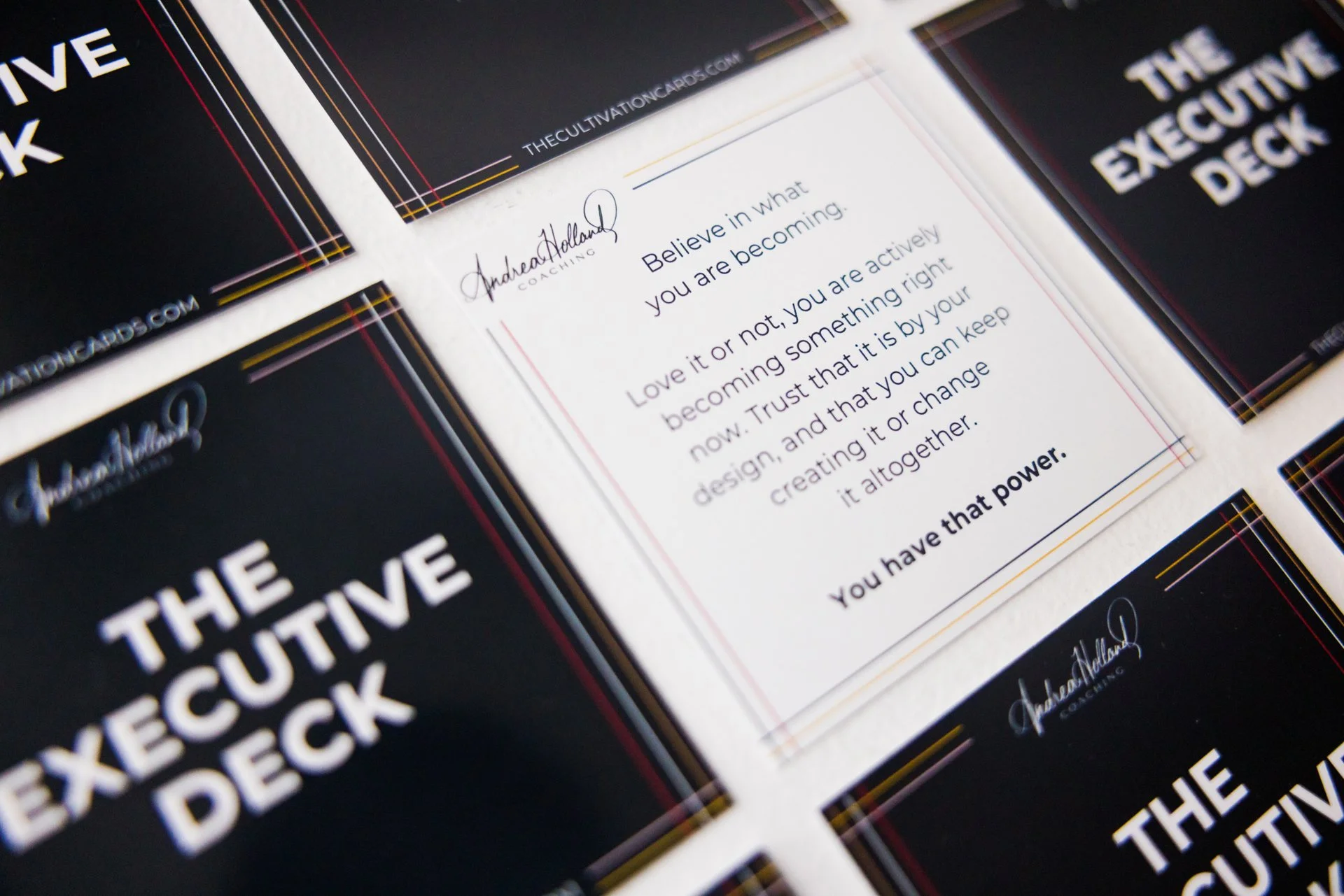 Close-up of promotional cards for "The Executive Deck" with one card featuring an inspirational message about believing in oneself and trusting the design of one's future.
