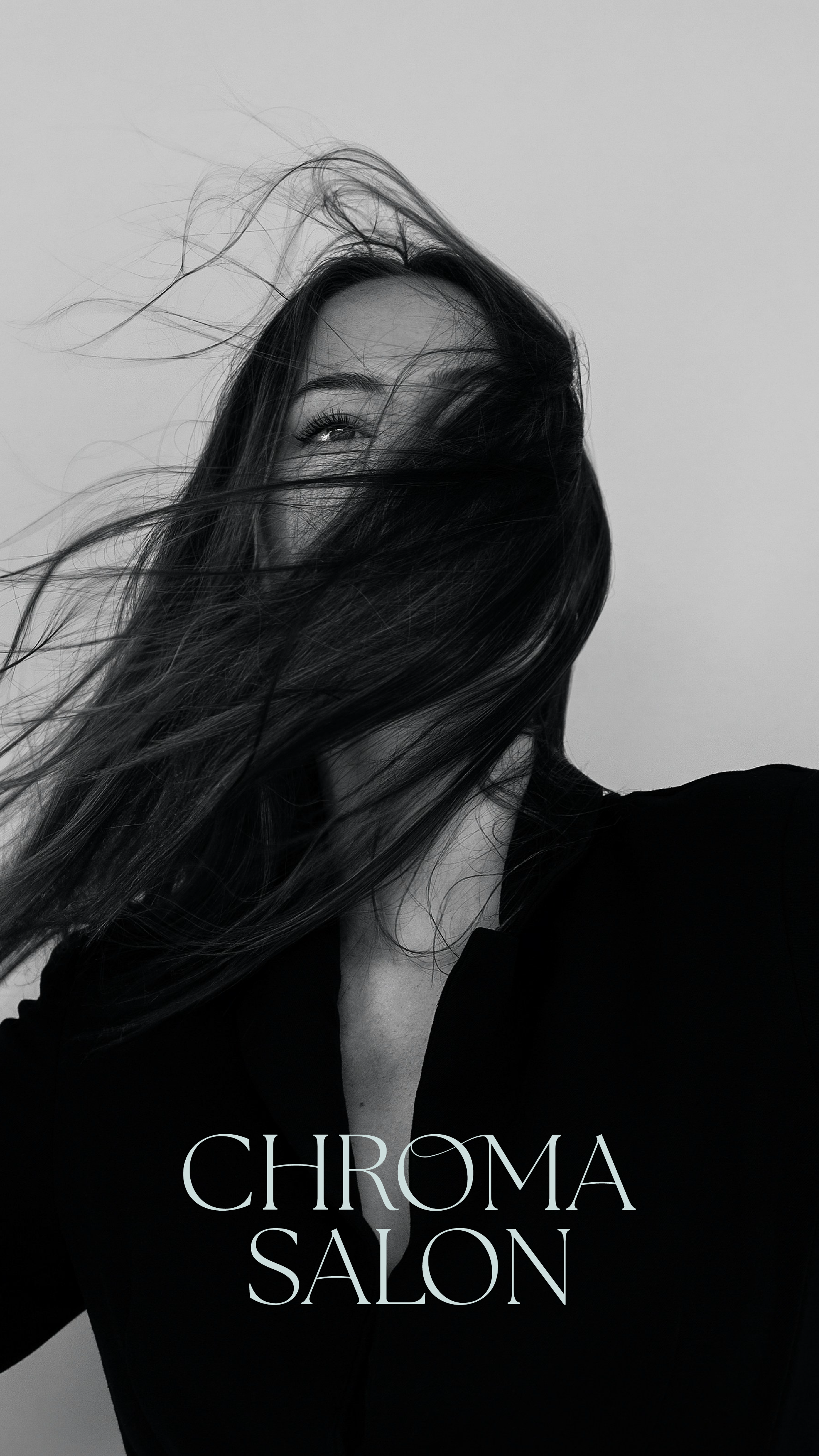 A black and white photo of a woman with long hair covering her face, with the logo for Chroma Salon at the bottom. The logo designed by Evelle Creative.