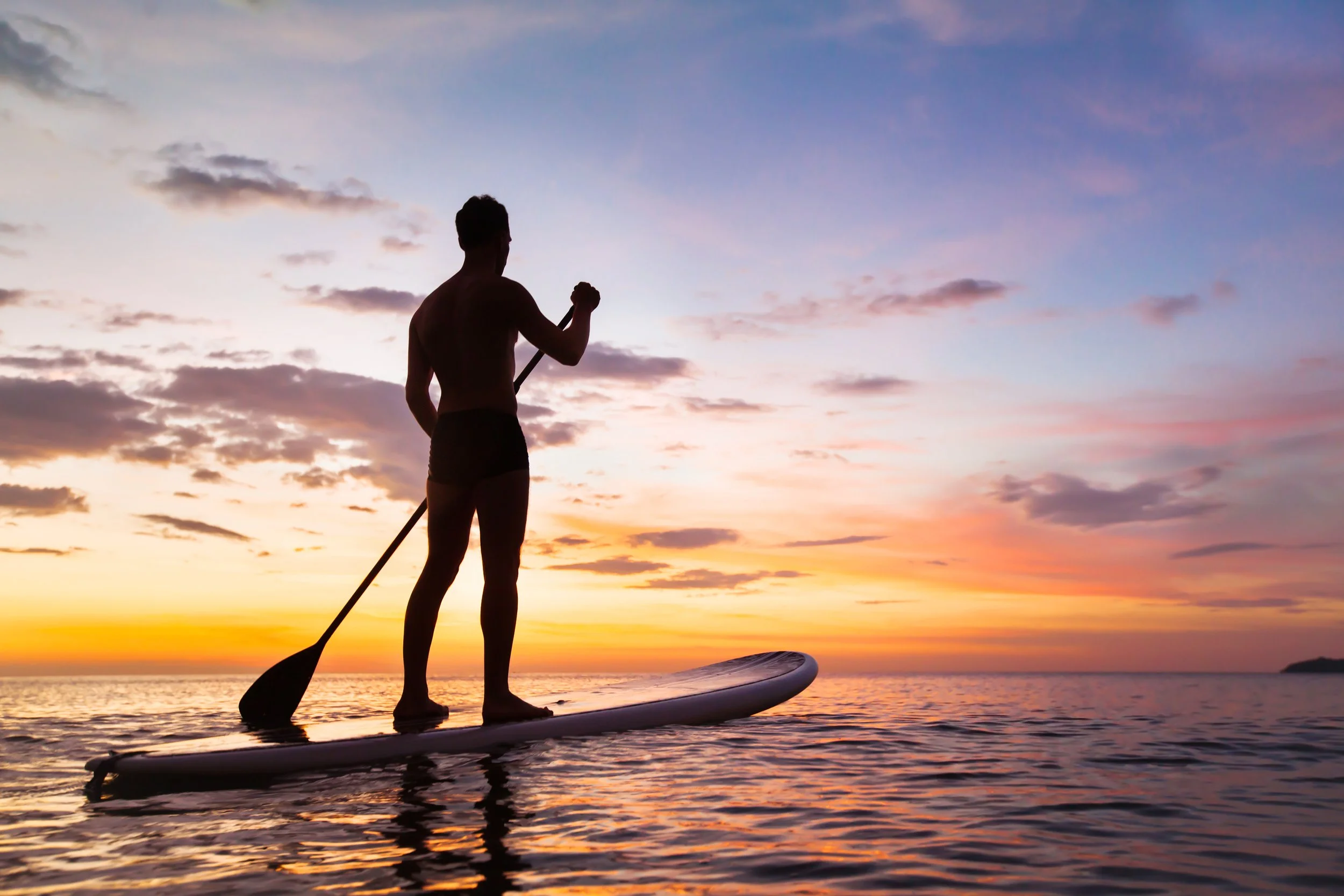 man-paddleboarding-at-sunset.jpeg