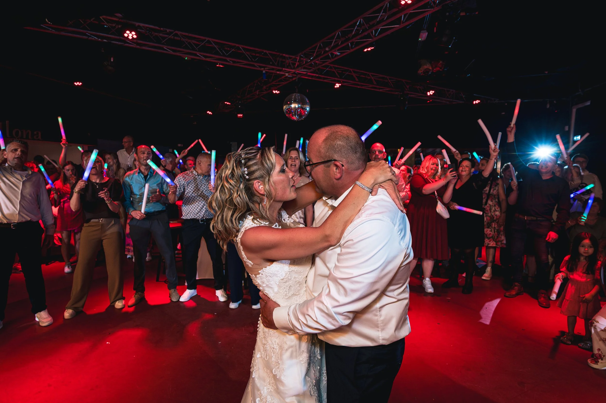 De bruid en bruidegom dansen samen hun openingsdans in De Lantaarn in Hellendoorn, omringd door hun gasten