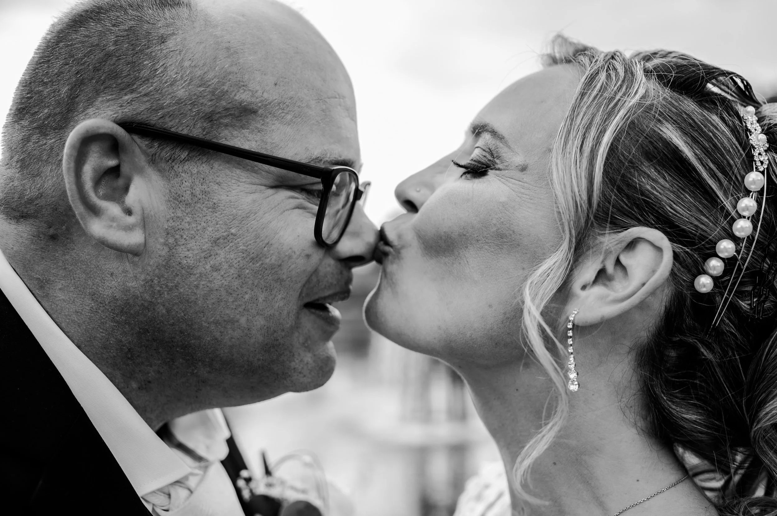 Close-up van de bruid die de bruidegom een liefdevol kusje op zijn neus geeft tijdens hun trouwdag in Hellendoorn