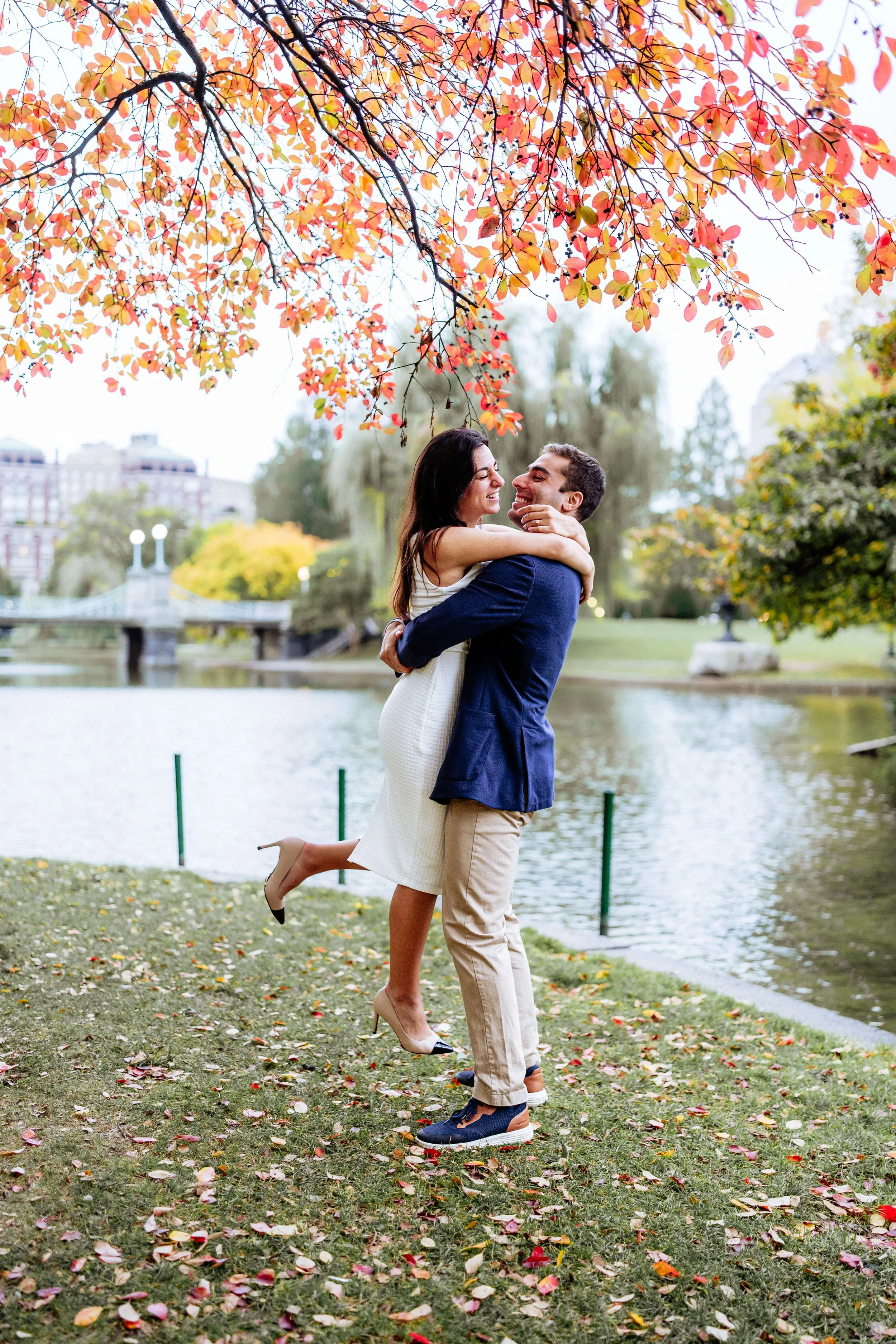 Couple embracing during a romantic fall couples photography session in Boston Public Garden.