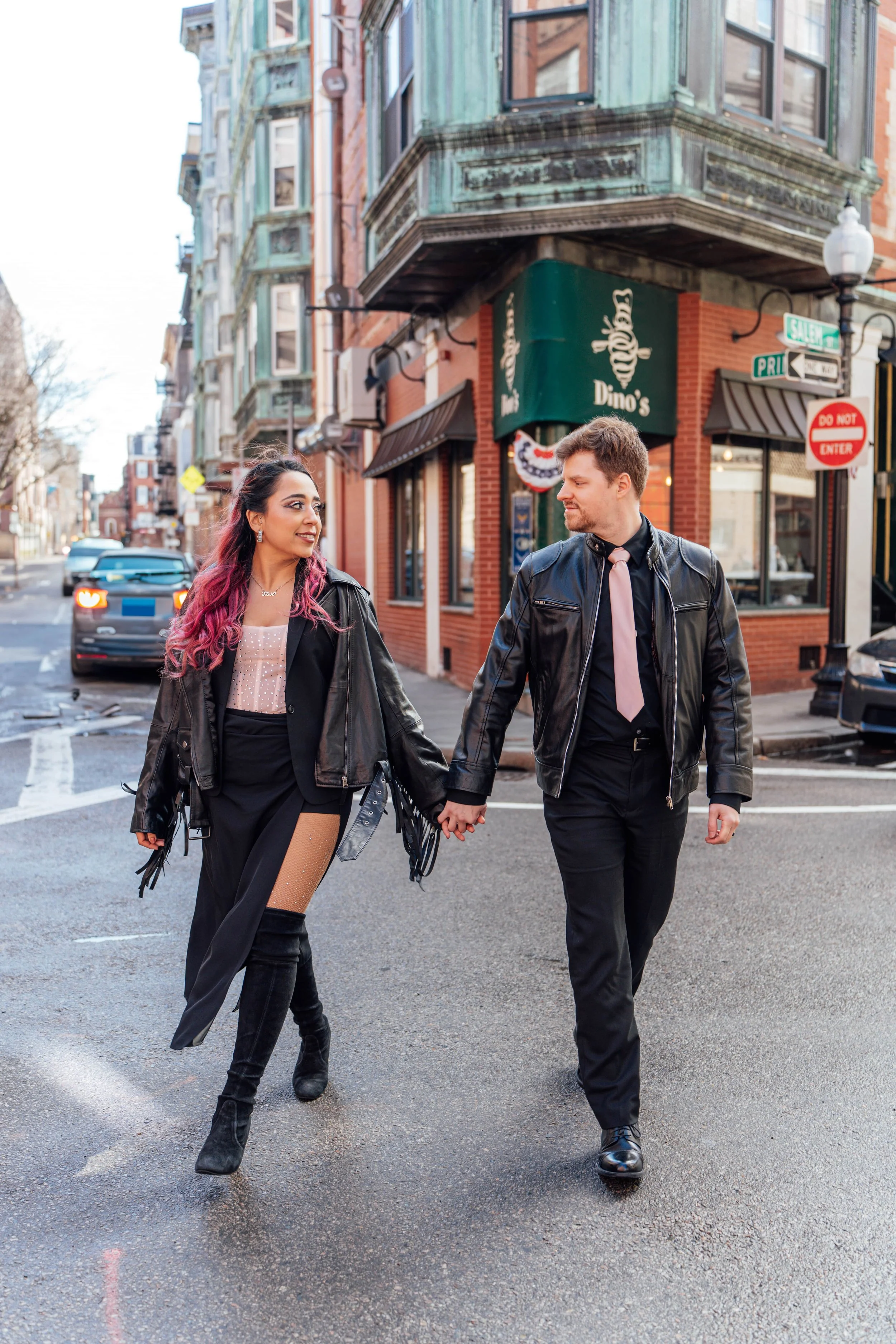 Couple walking hand in hand during a cinematic autumn couples photography session in North End, Boston.