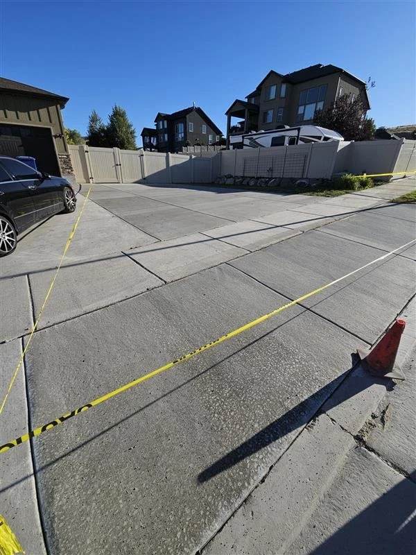 After photo of new concrete parking area with cut out curb, by Your Handyman Pros.