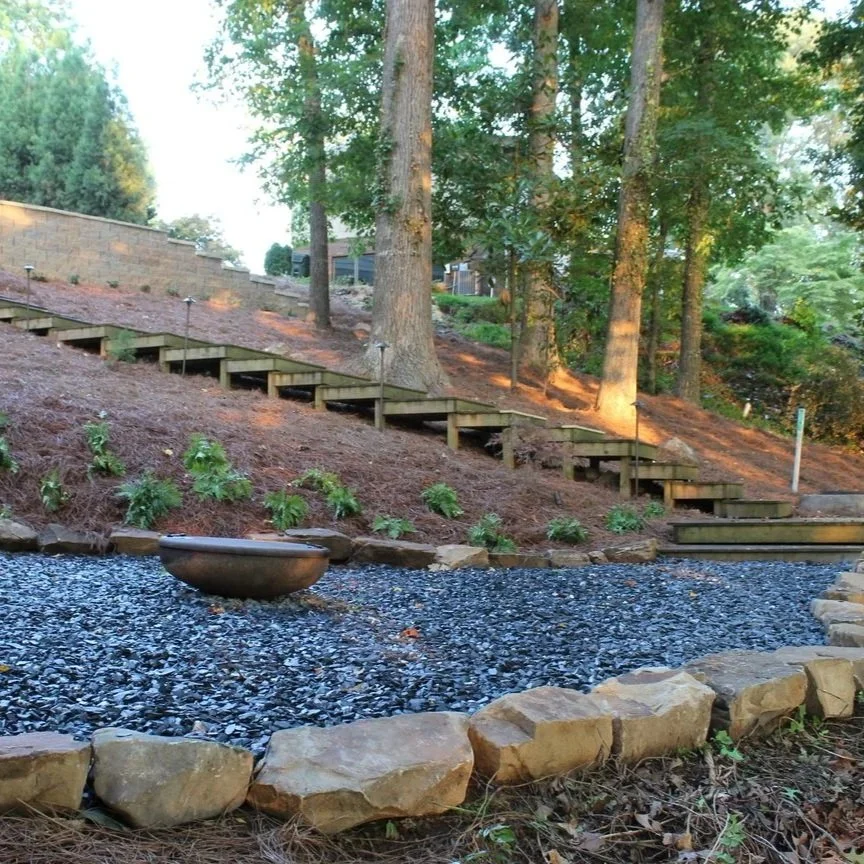Sloped yard in Gainesville, GA showing interlocking pavers with proper base and drainage to prevent shifting or erosion.