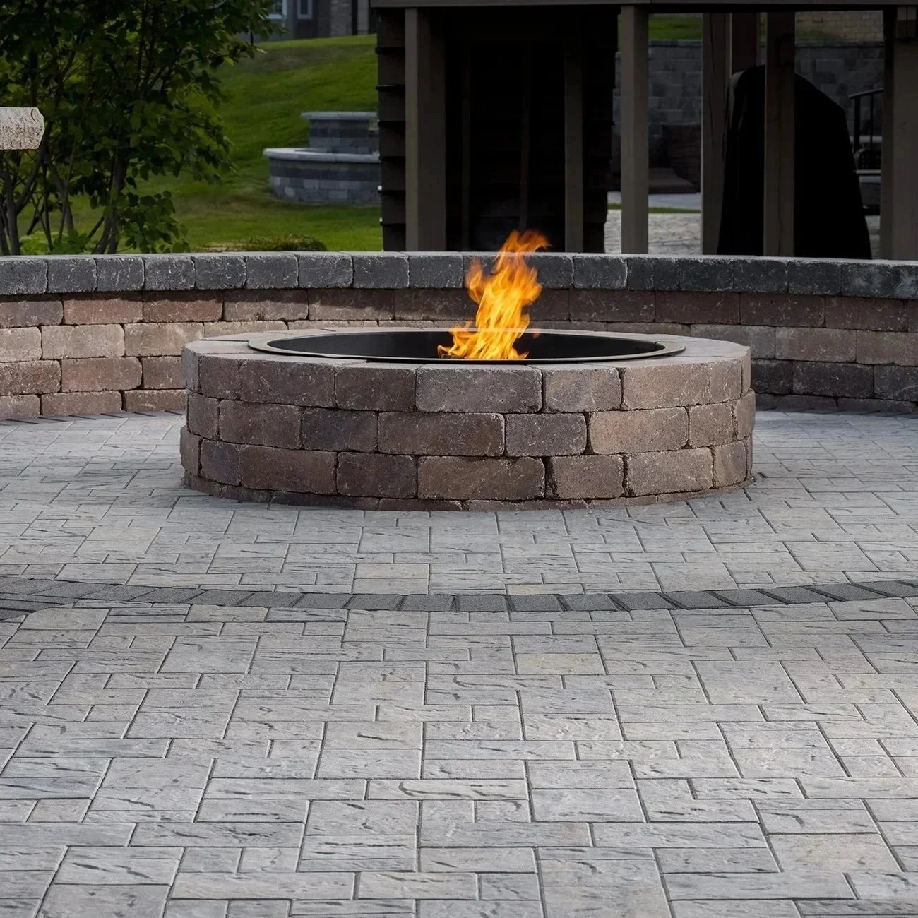 Fire pit with built-in grill in backyard, flames glowing, cooking steaks and vegetables, creating cozy, inviting outdoor ambiance.