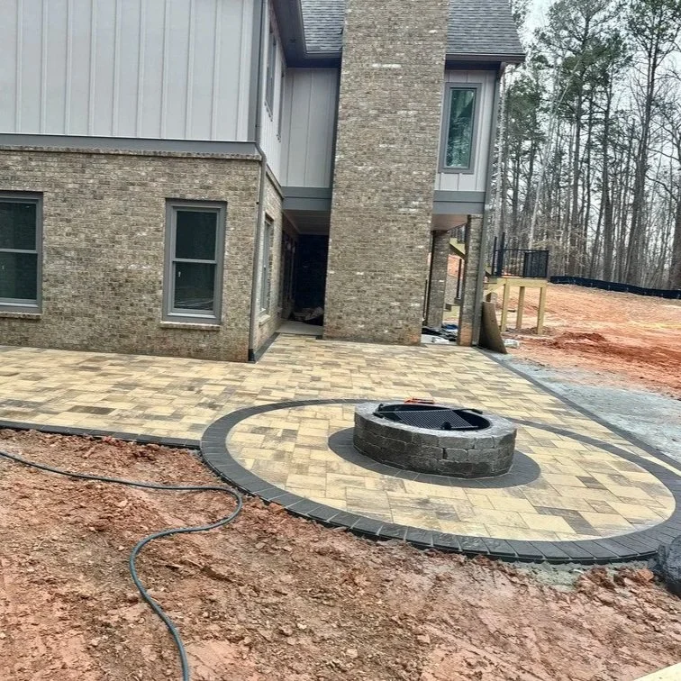 Fire pit outdoors after long-term storage, showing metal components, gas lines, burner ports, and fire media needing inspection.