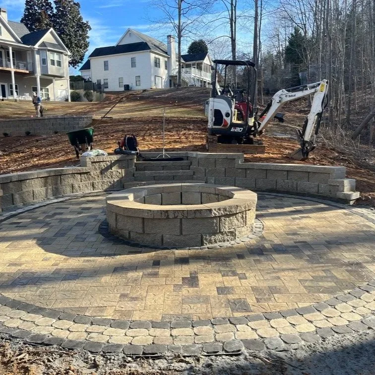 Backyard fire pit installation site with leveled ground, stone base, and clear space for safe wood-burning or gas setup.