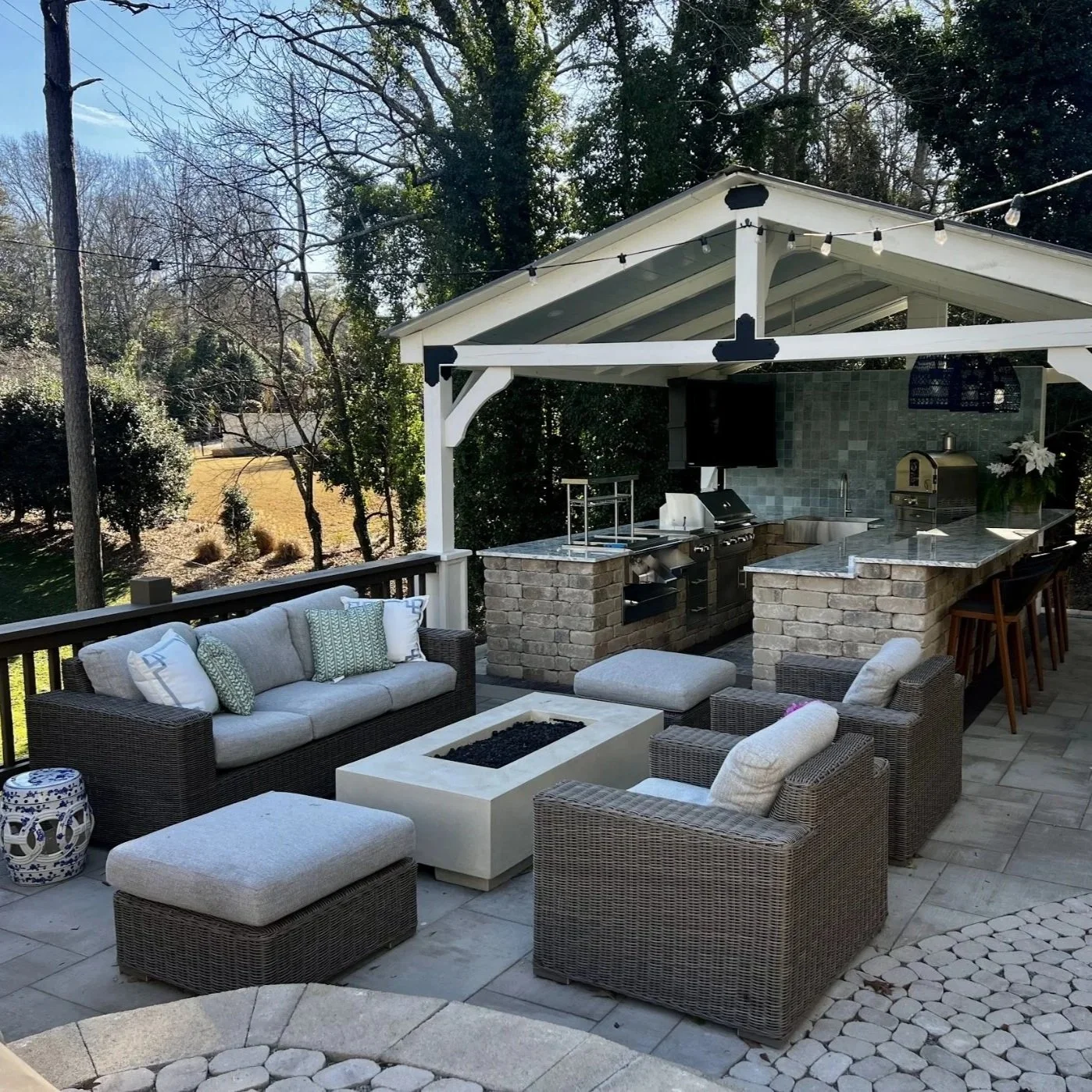 Gainesville backyard with a central fire pit, surrounded by seating, native plants, and cozy evening lighting for gatherings.