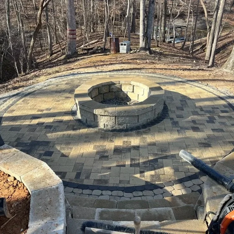 Outdoor fire pit burning with flames, surrounded by chairs, illustrating wood, propane, and natural gas options for backyard gatherings.