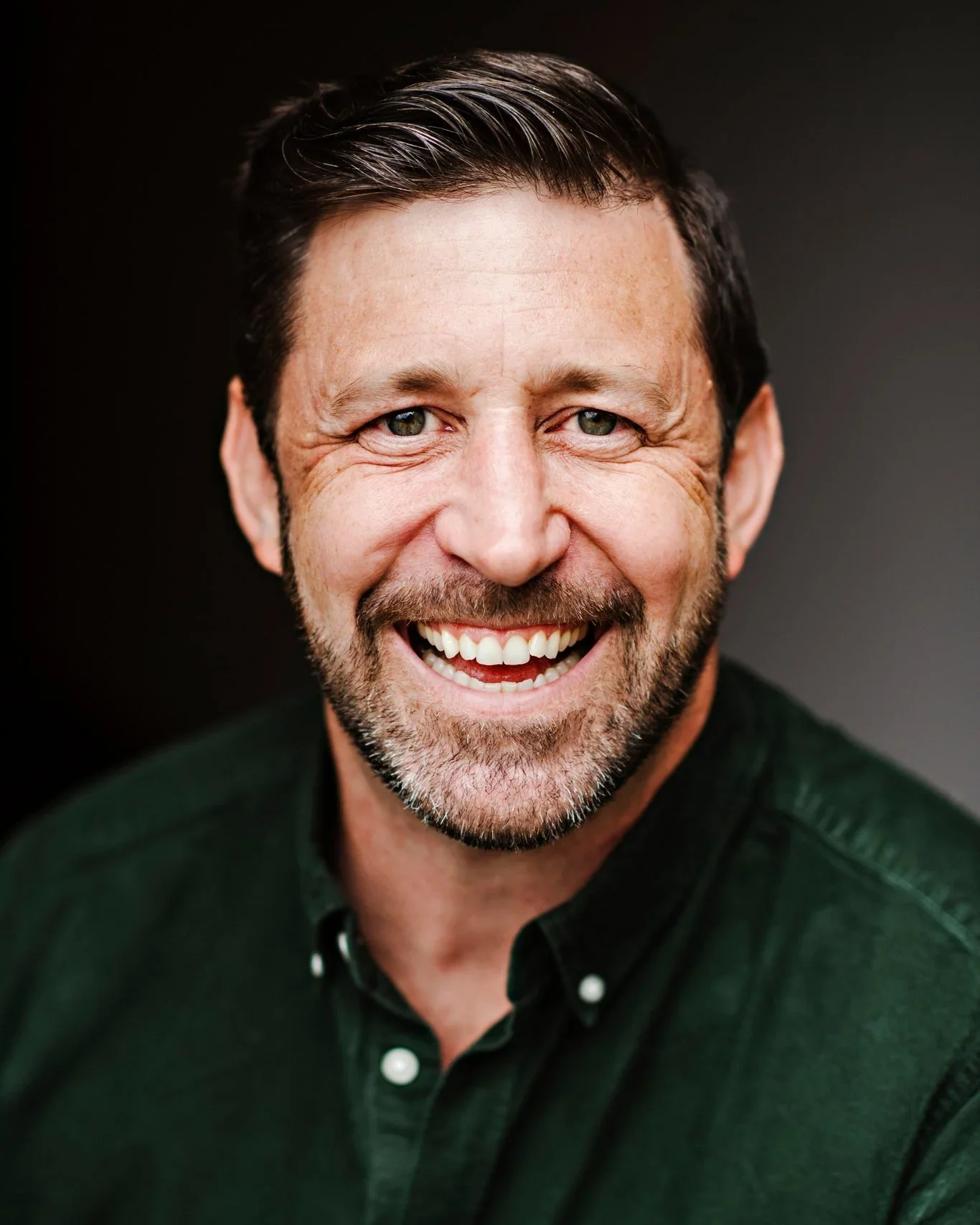Jim Moss smiling in front of the Gratitude Wall — Trust and Community Leadership Speaker
