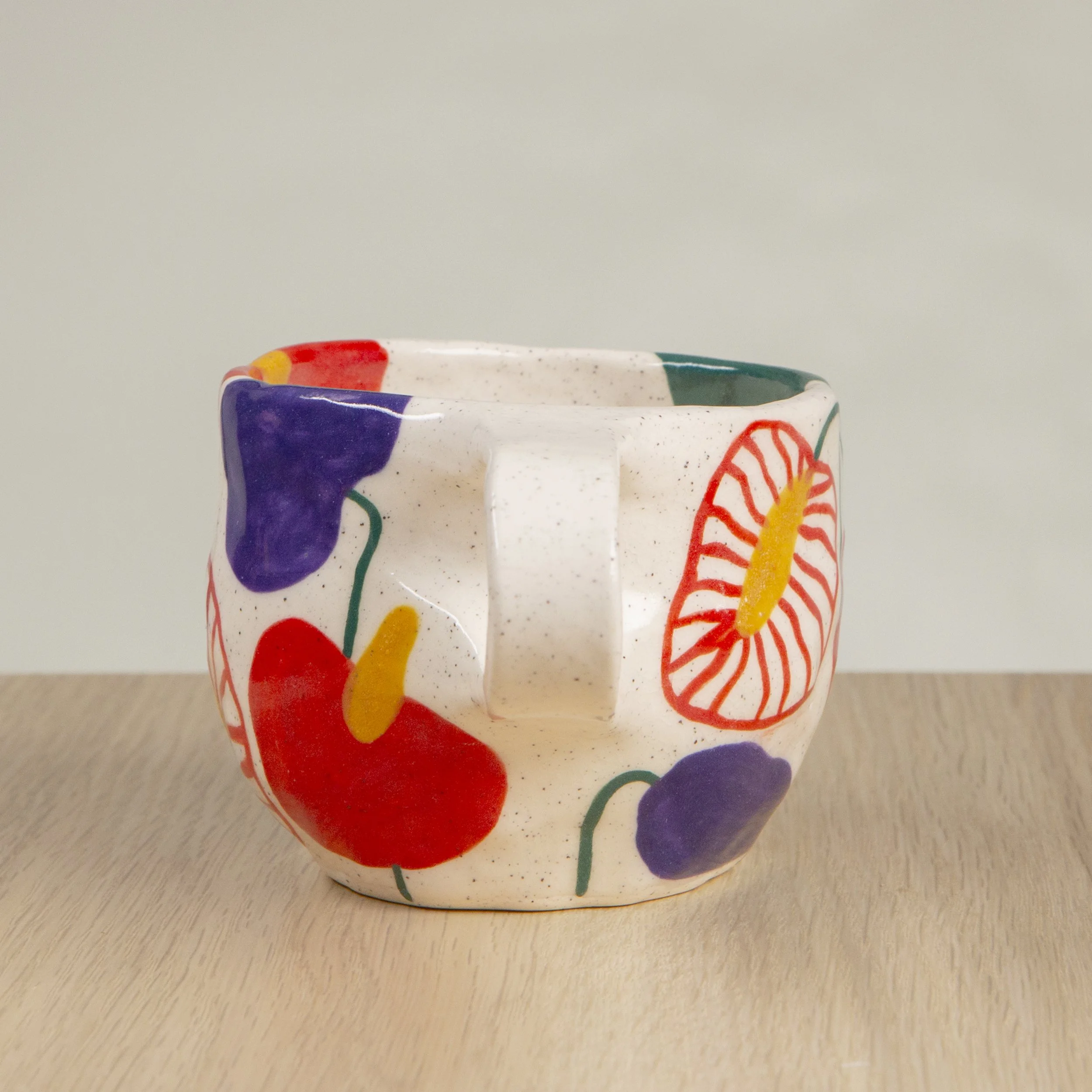 Handmade ceramic coffee cup with hand-painted anthurium flowers, crafted from speckled clay in Melbourne. Holds approximately 150ml.