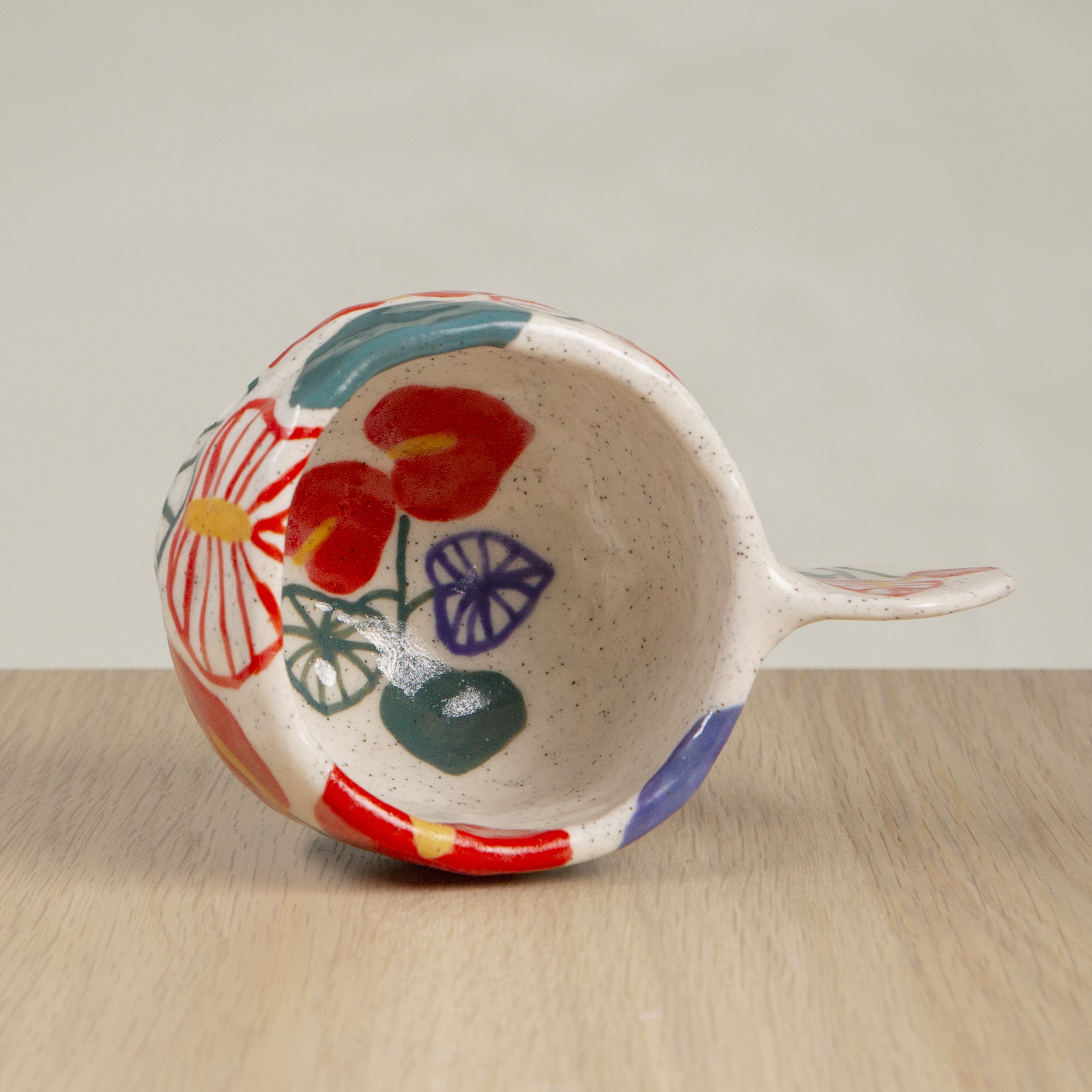 Handmade ceramic coffee cup with hand-painted anthurium flowers, crafted from speckled clay in Melbourne with a cute petal handle. Holds approximately 150ml.