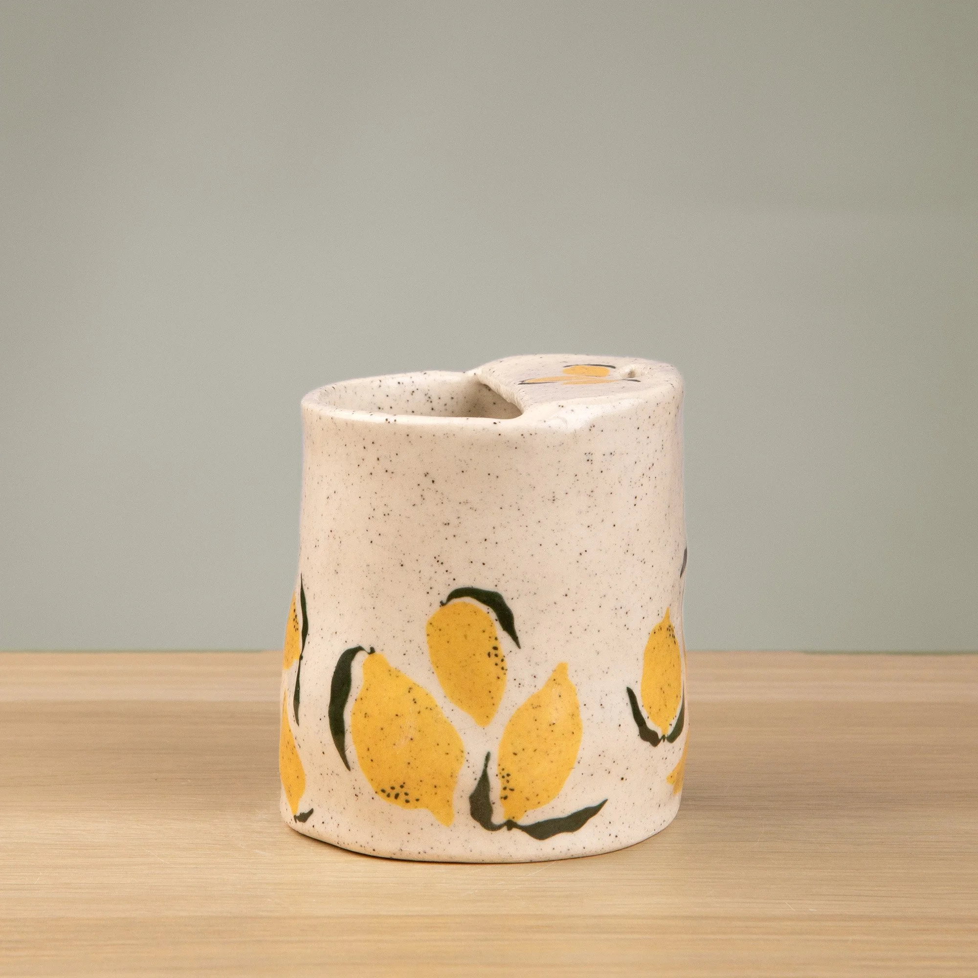 Handmade speckled ceramic lemon travel cup decorated with sweet lemon illustrations