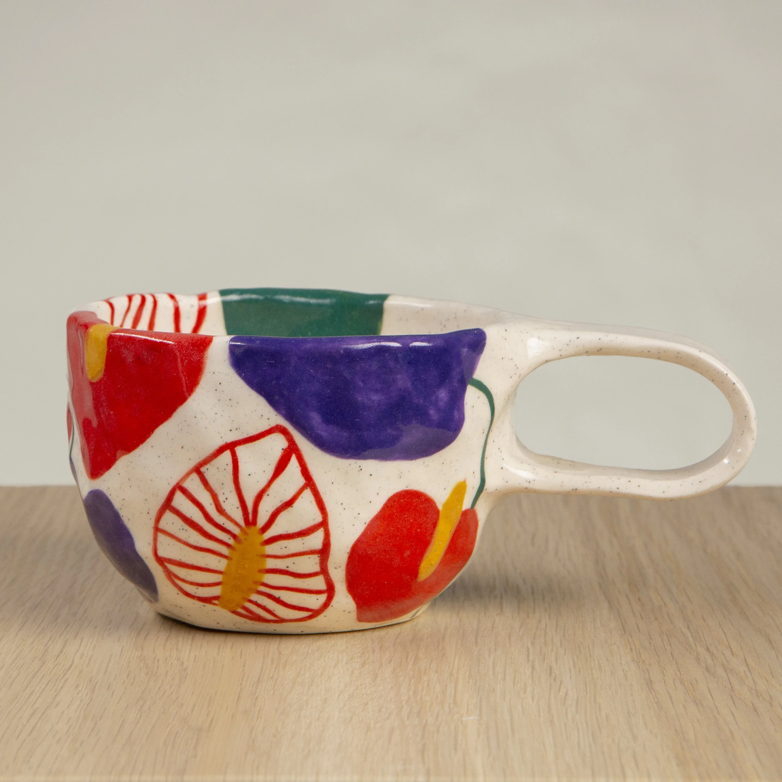 Handmade ceramic mug with hand-painted anthurium flower design, crafted from speckled clay in Melbourne. Holds approximately 300ml.