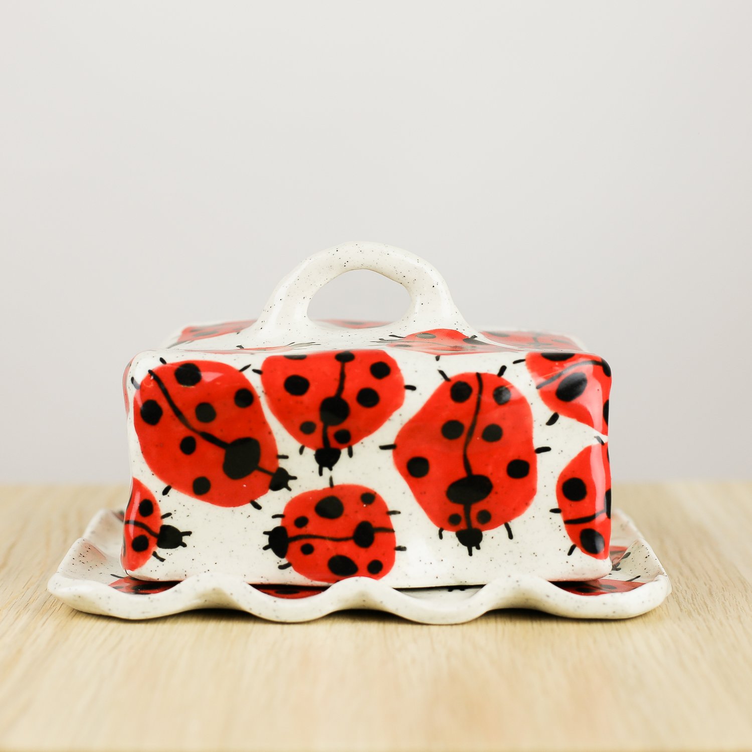 Handmade ceramic butter dish featuring a loveliness of hand-painted ladybugs. Fits 450–500g butter. A unique, whimsical piece to brighten your table.