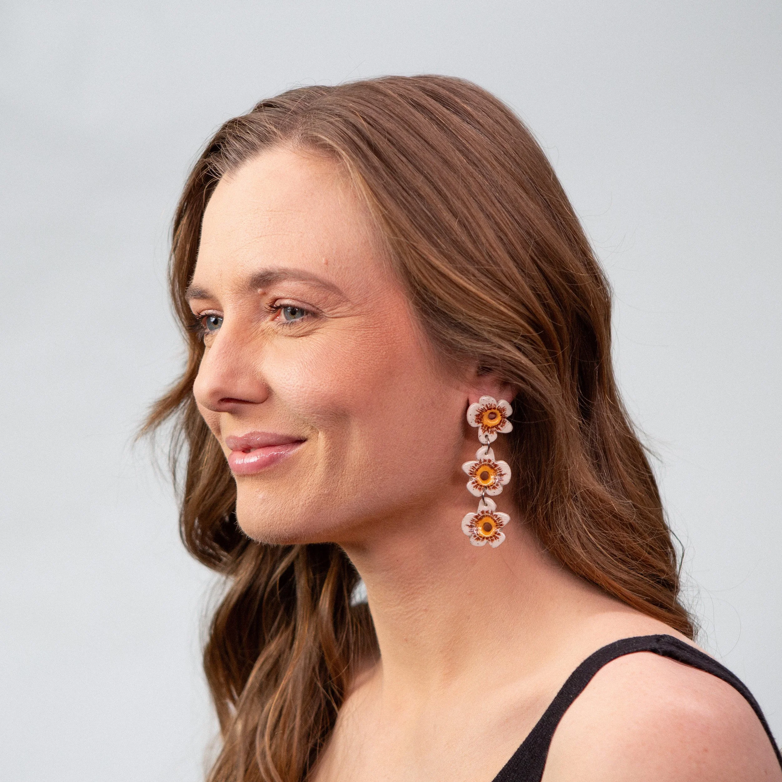 Three-tier handmade ceramic earrings featuring 3 white flowers designed by Hellomae
