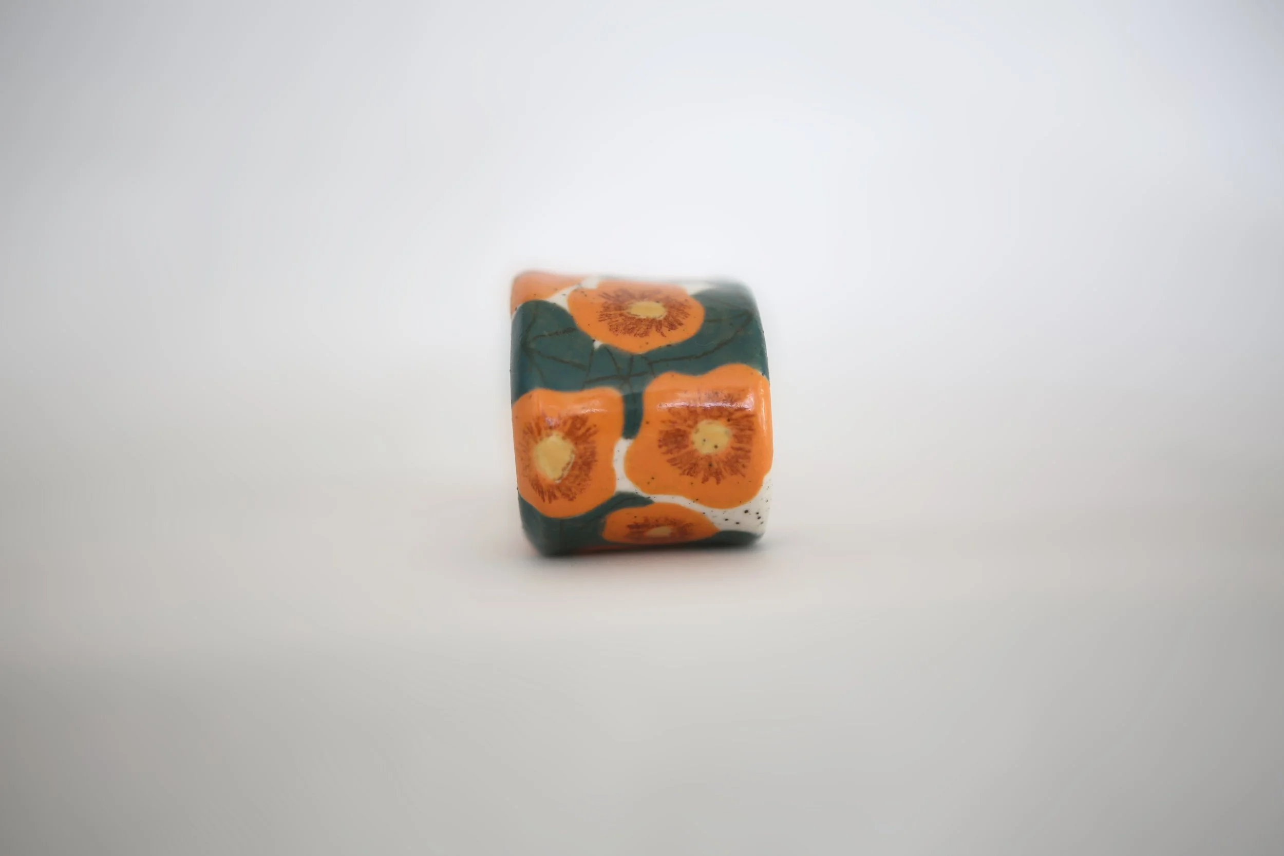 Ceramic napkin ring with wonky nasturtium design, off white speckled clay base, with matching napkin.