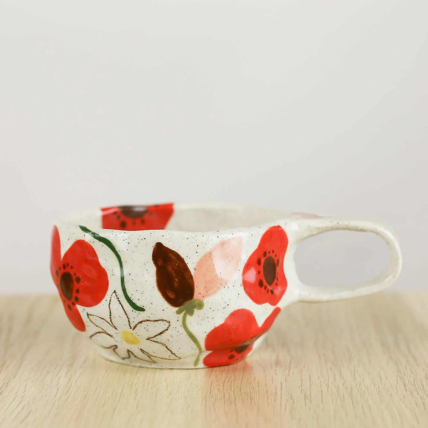 Handmade ceramic cup with hand-painted poppies, daisies and sweet pea flowers. Holds 150ml. A unique floral coffee cup for everyday rituals.