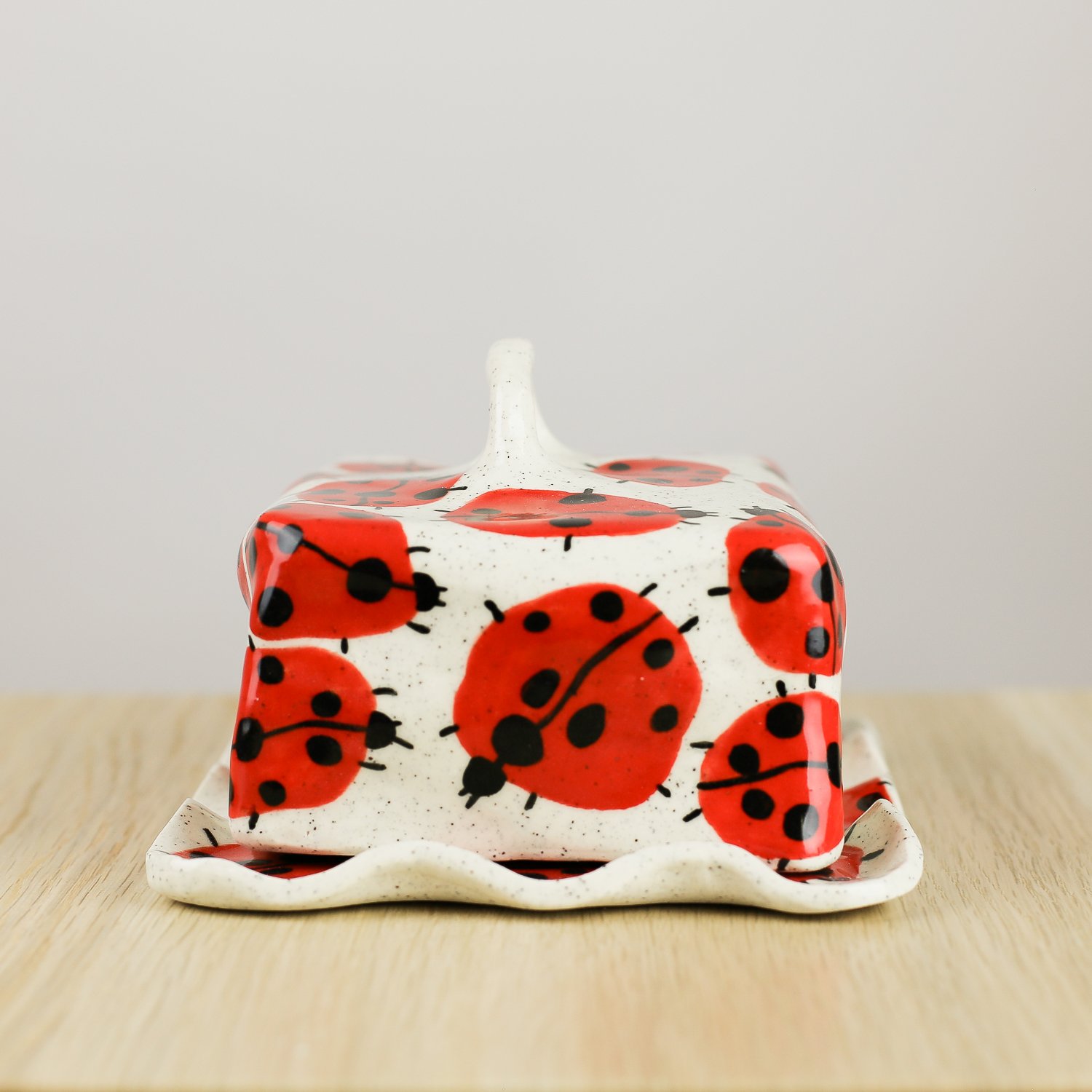 Handmade ceramic butter dish featuring a loveliness of hand-painted ladybugs. Fits 450–500g butter. A unique, whimsical piece to brighten your table.