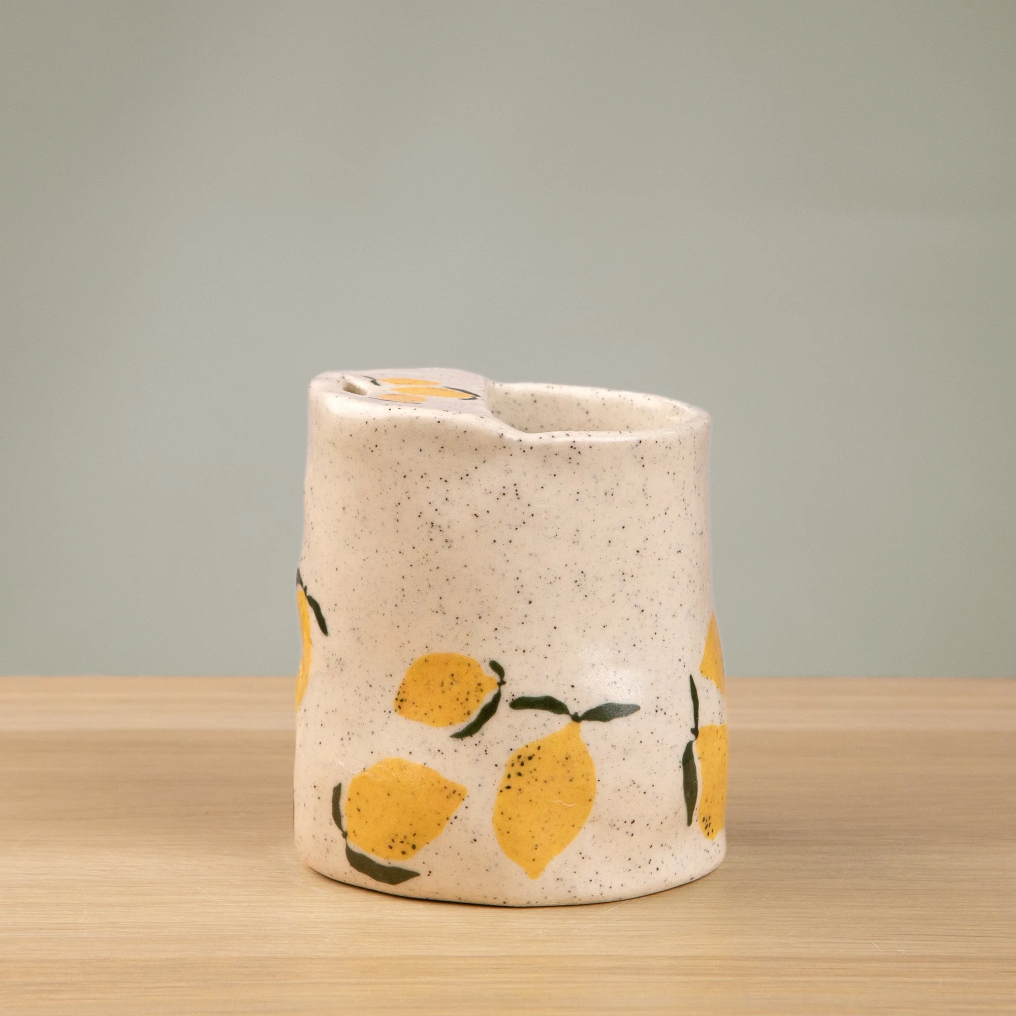 Handmade speckled ceramic lemon travel cup decorated with sweet lemon illustrations