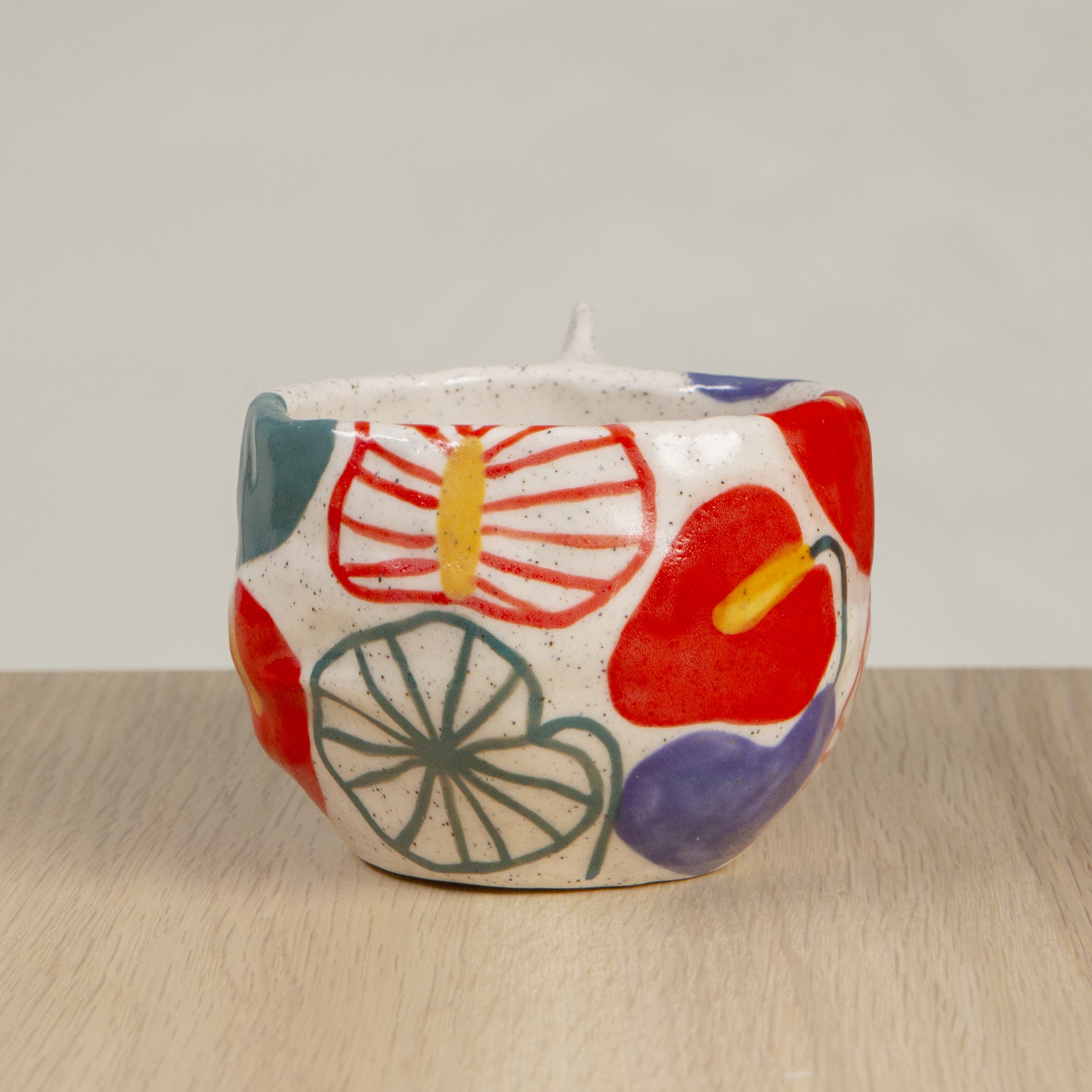Handmade ceramic coffee cup with hand-painted anthurium flowers, crafted from speckled clay in Melbourne with a cute petal handle. Holds approximately 150ml.