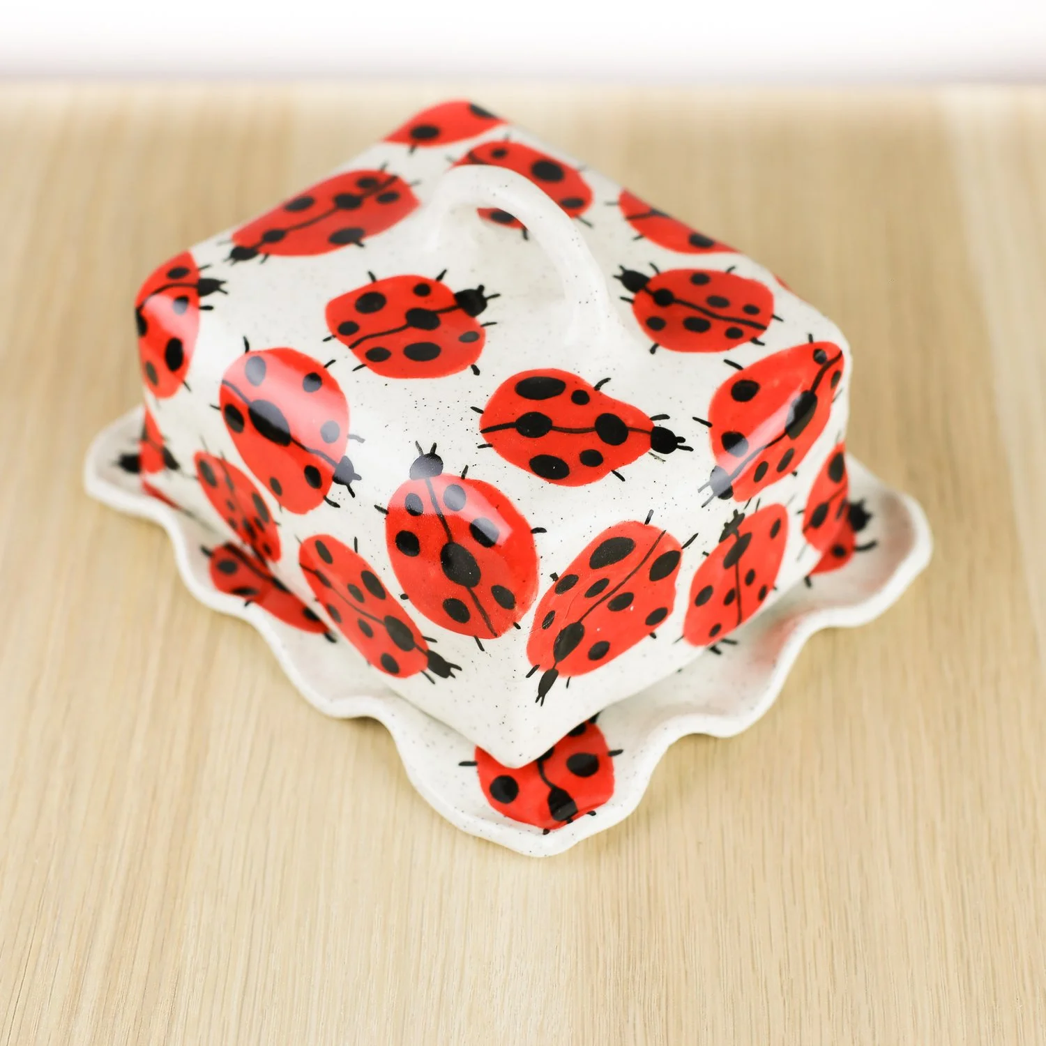 Handmade ceramic butter dish featuring a loveliness of hand-painted ladybugs. Fits 450–500g butter. A unique, whimsical piece to brighten your table.