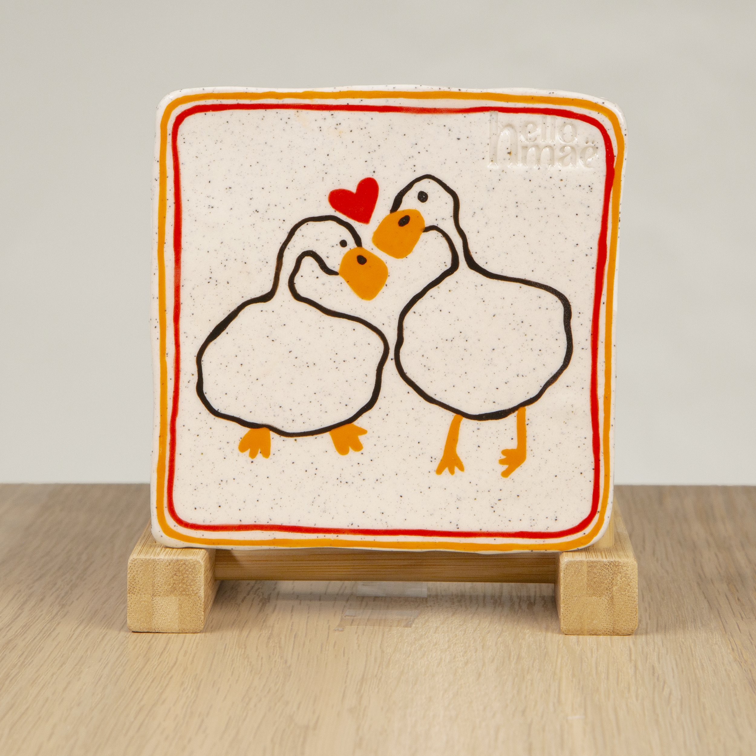 Handmade ceramic coaster featuring a hand-painted loving ducks & red/orange 2 lines design on speckled clay. A sweet addition to your tableware, made in Melbourne by hellomaë.