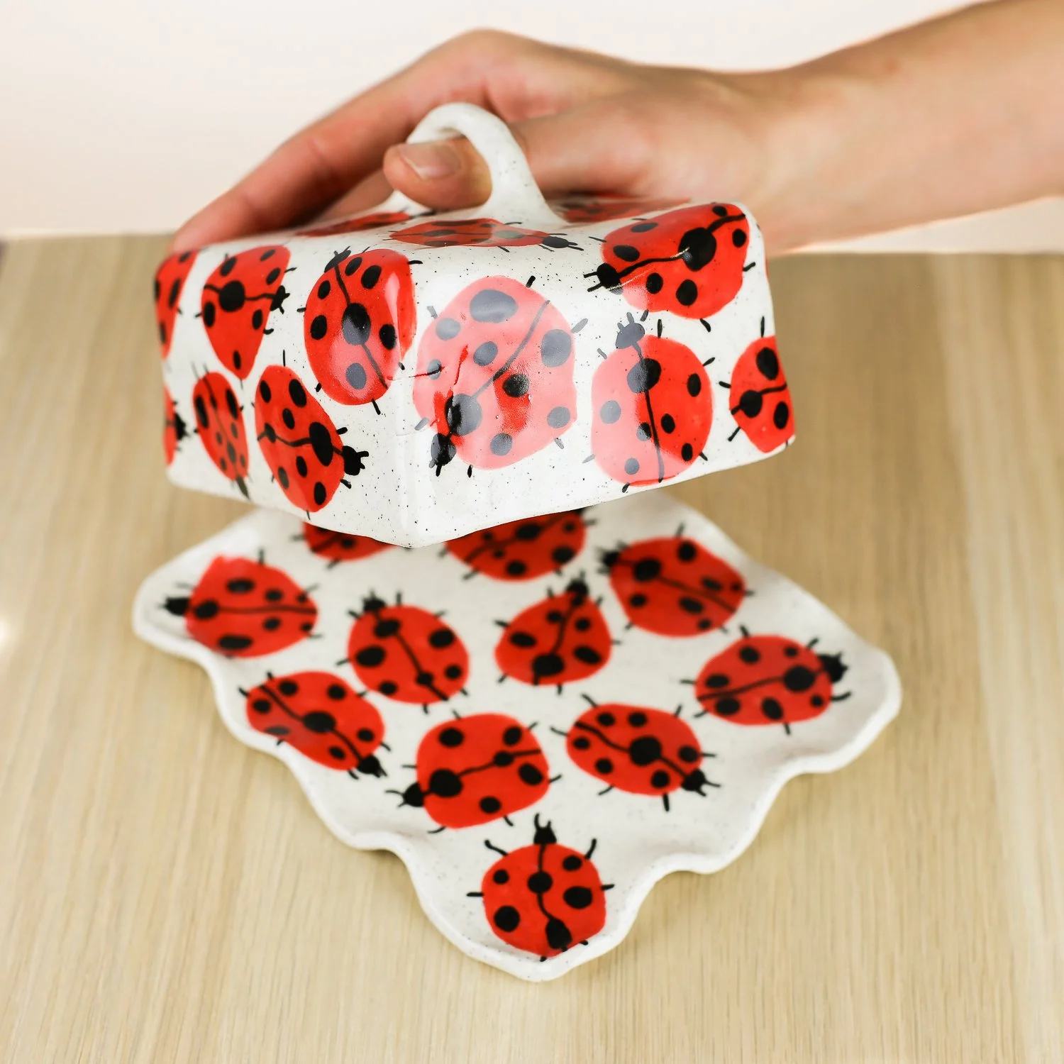 Handmade ceramic butter dish featuring a loveliness of hand-painted ladybugs. Fits 450–500g butter. A unique, whimsical piece to brighten your table.