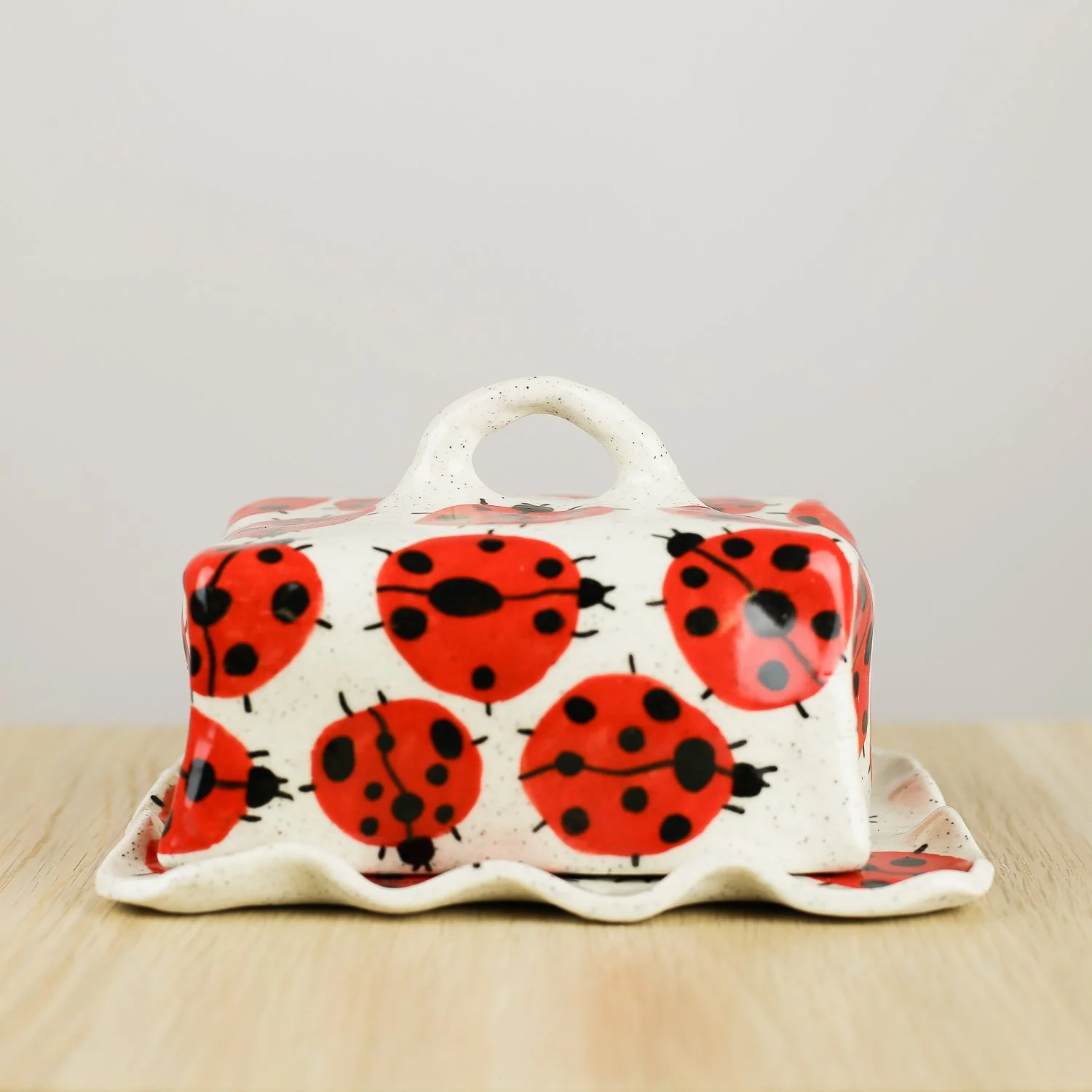 Handmade ceramic butter dish featuring a loveliness of hand-painted ladybugs. Fits 450–500g butter. A unique, whimsical piece to brighten your table.