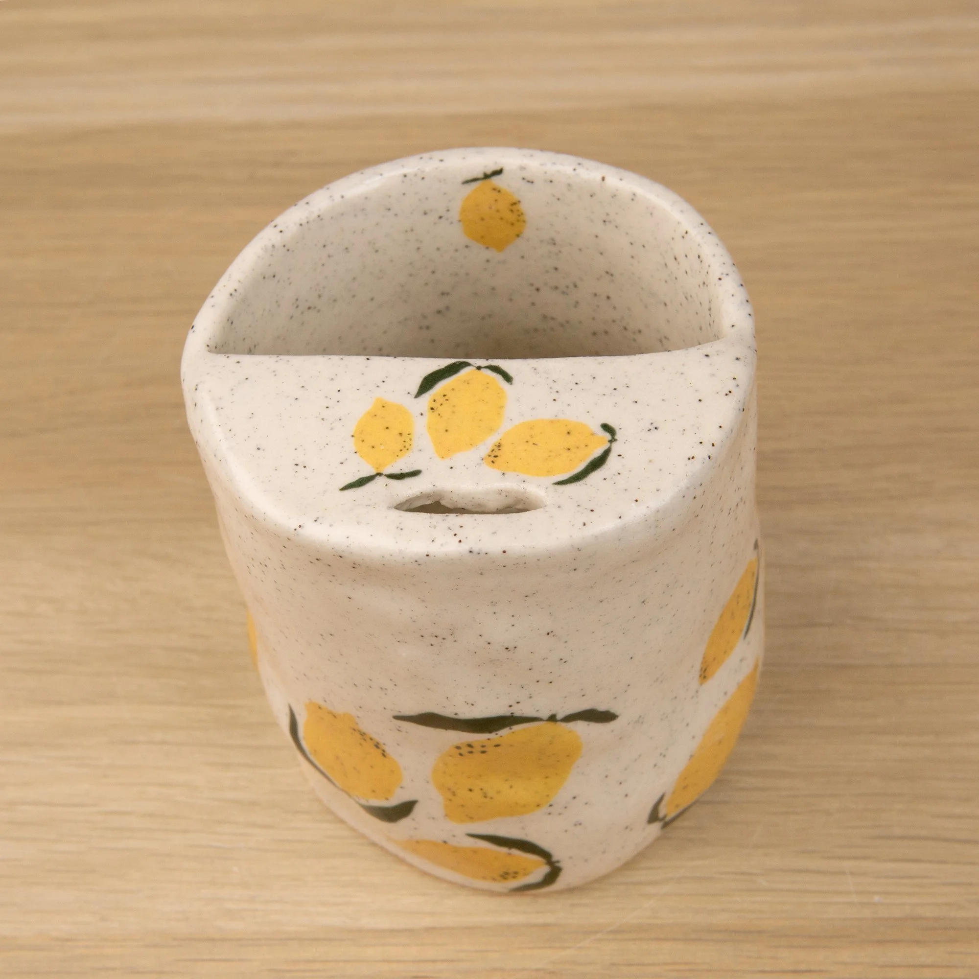 Handmade speckled ceramic lemon travel cup decorated with sweet lemon illustrations