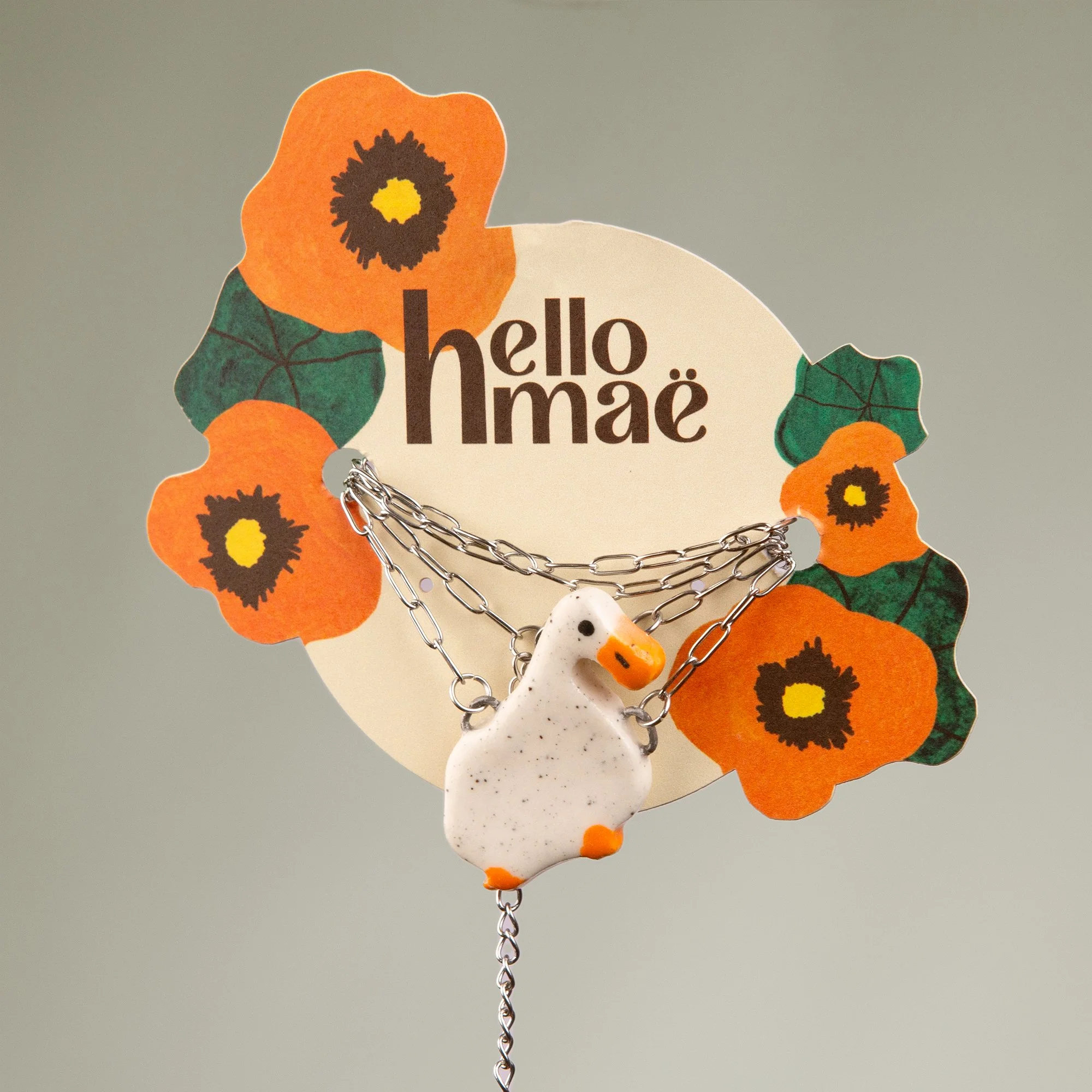 Handmade ceramic duck necklace featuring a playful hand-painted duck pendant on a silver-coloured chain.