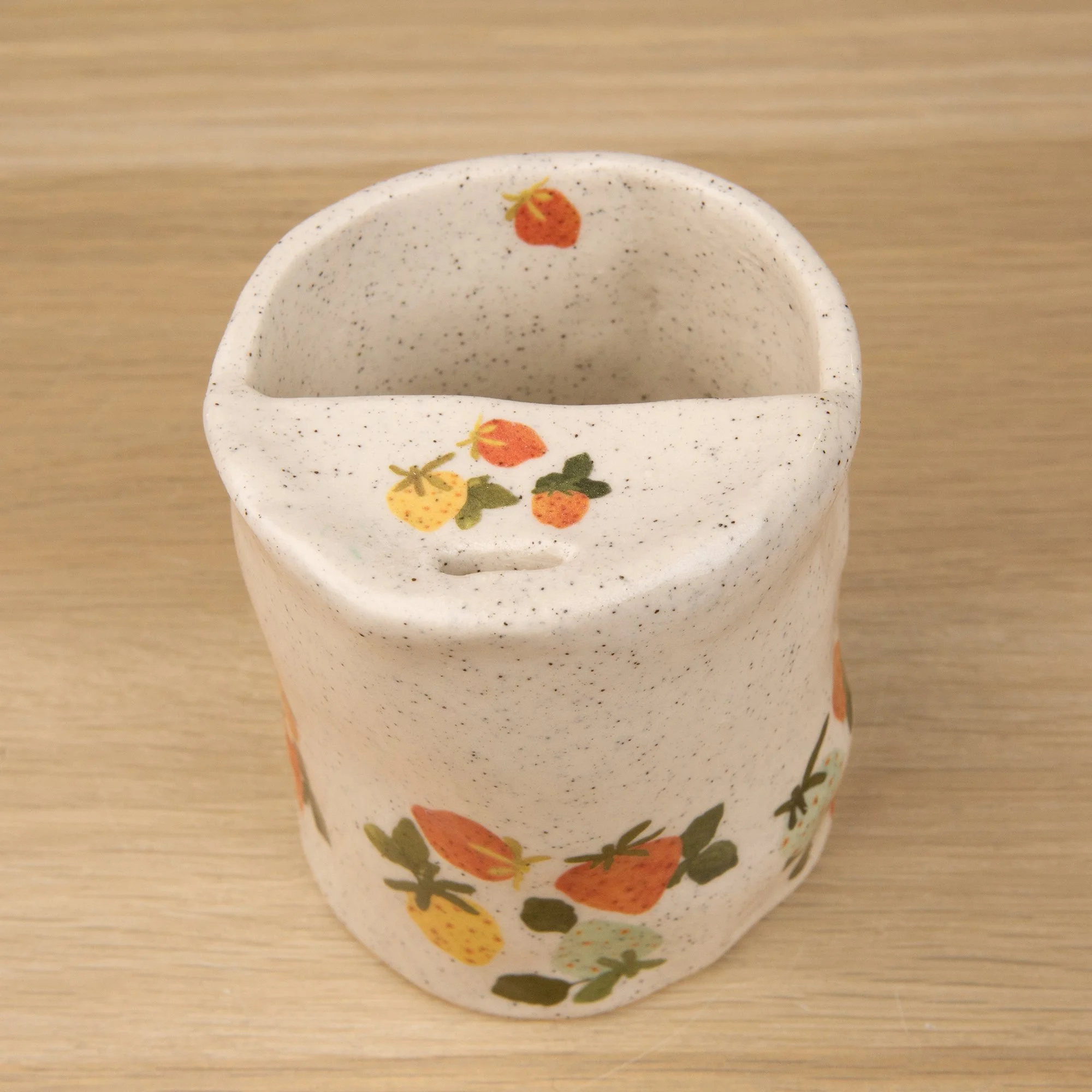 Handmade speckled ceramic strawberry dream travel cup decorated with sweet red, pink, yellow and blue strawberries