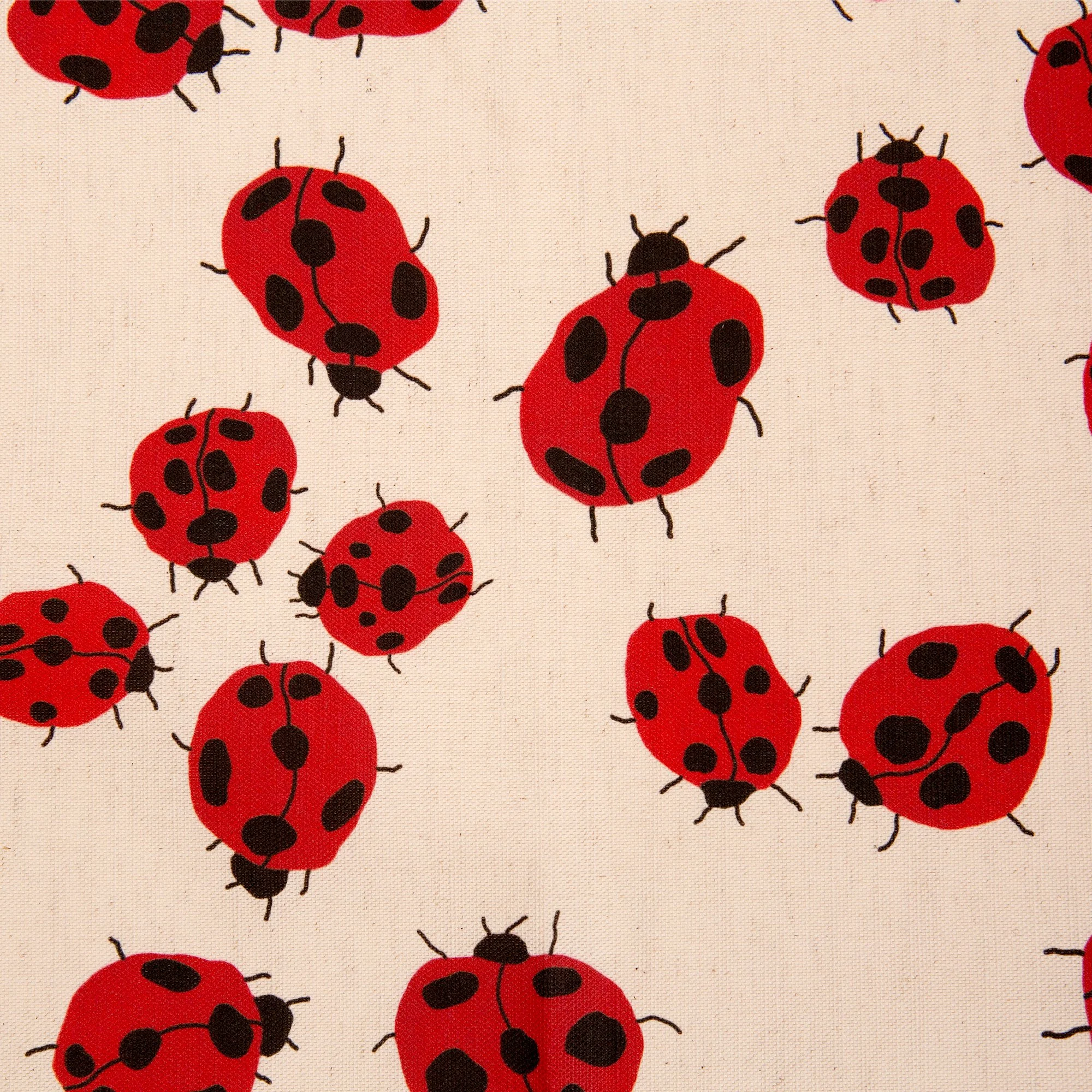 Colourful Loveliness tea towel featuring a playful print of red ladybugs and garden-inspired details.