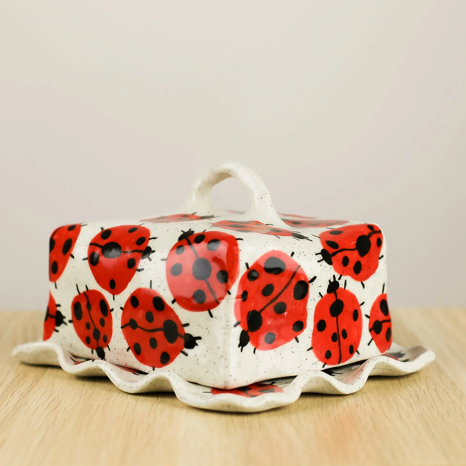 Handmade ceramic butter dish featuring a loveliness of hand-painted ladybugs. Fits 450–500g butter. A unique, whimsical piece to brighten your table.
