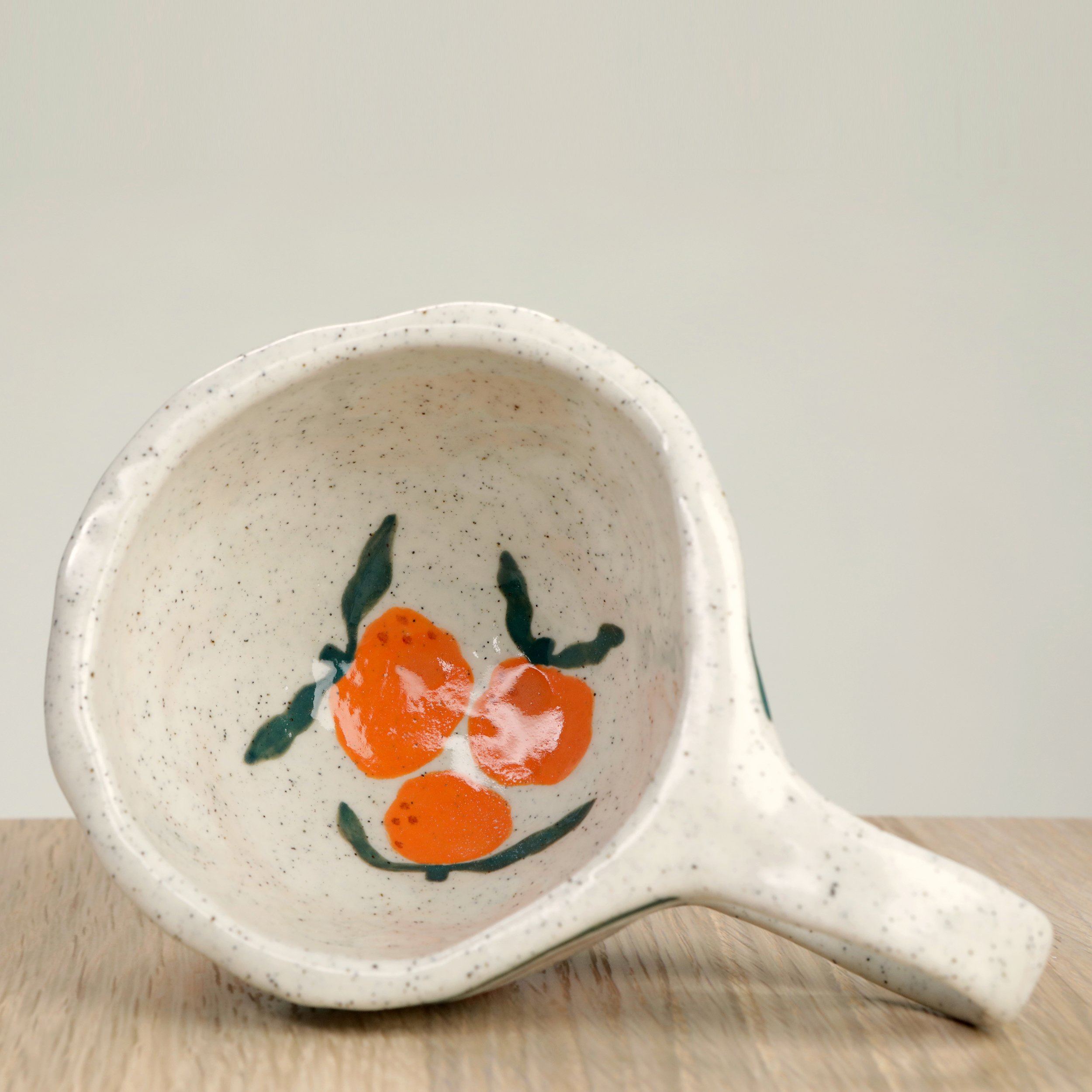 Handmade ceramic coffee cup with hand-painted mandarins & 2 lines border, crafted from speckled clay in Melbourne. Holds approximately 150ml.