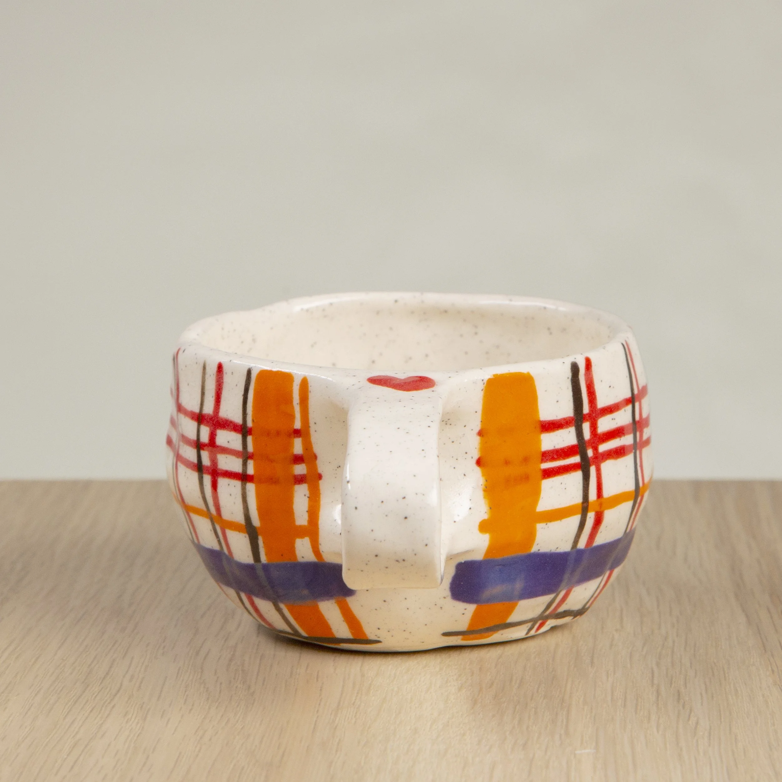 Handmade ceramic coffee cup with hand-painted orange/red/blue/brown check, crafted from speckled clay in Melbourne. Holds approximately 150ml.