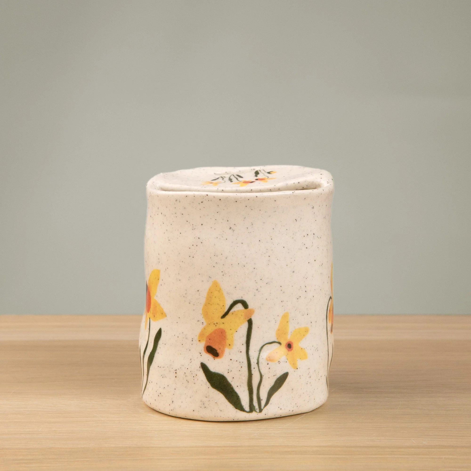 Handmade speckled ceramic daffodil travel cup decorated with sweet daffodil flowers illustrations