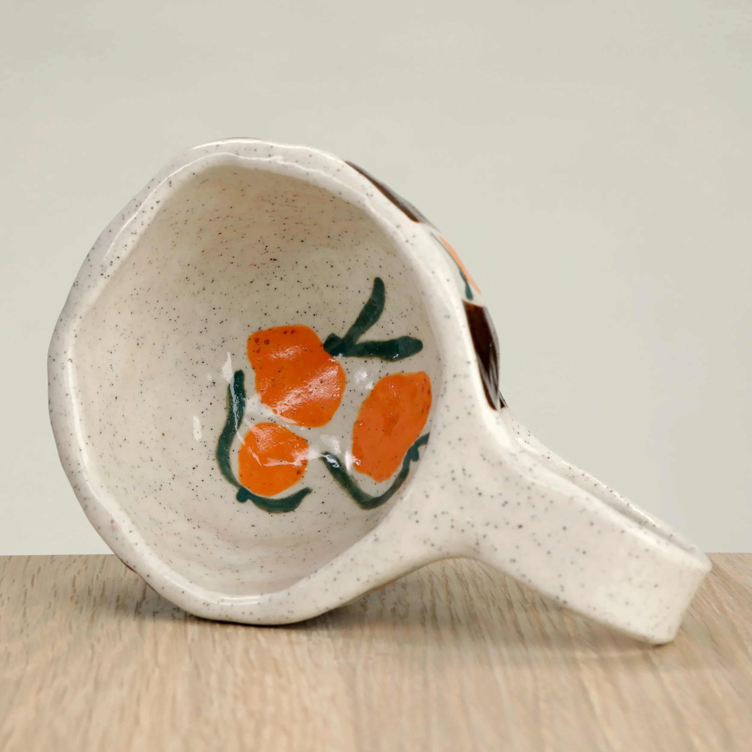 Handmade ceramic coffee cup with hand-painted mandarins & a chocolate check, crafted from speckled clay in Melbourne. Holds approximately 300ml.