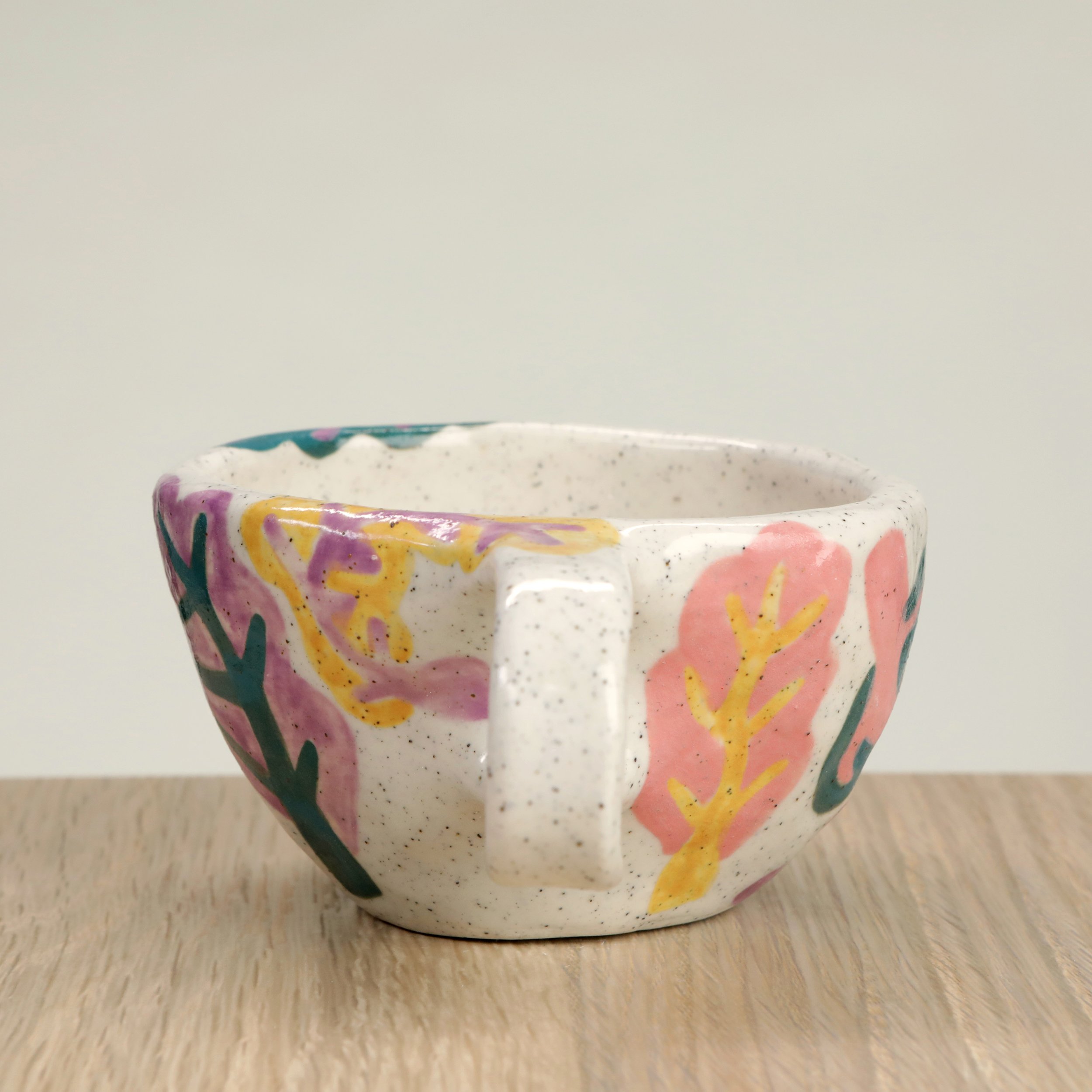 Handmade ceramic coffee cup with hand-painted rainbow chards, crafted from speckled clay in Melbourne. Holds approximately 150ml.