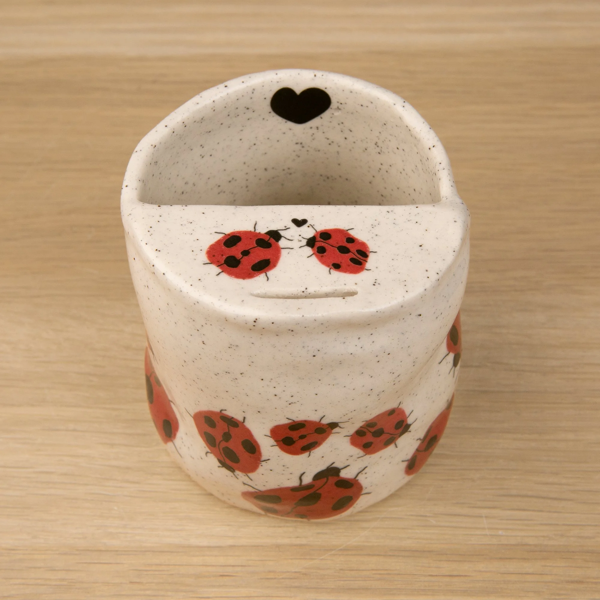 Handmade speckled ceramic Loveliness travel cup decorated with cheerful red ladybugs