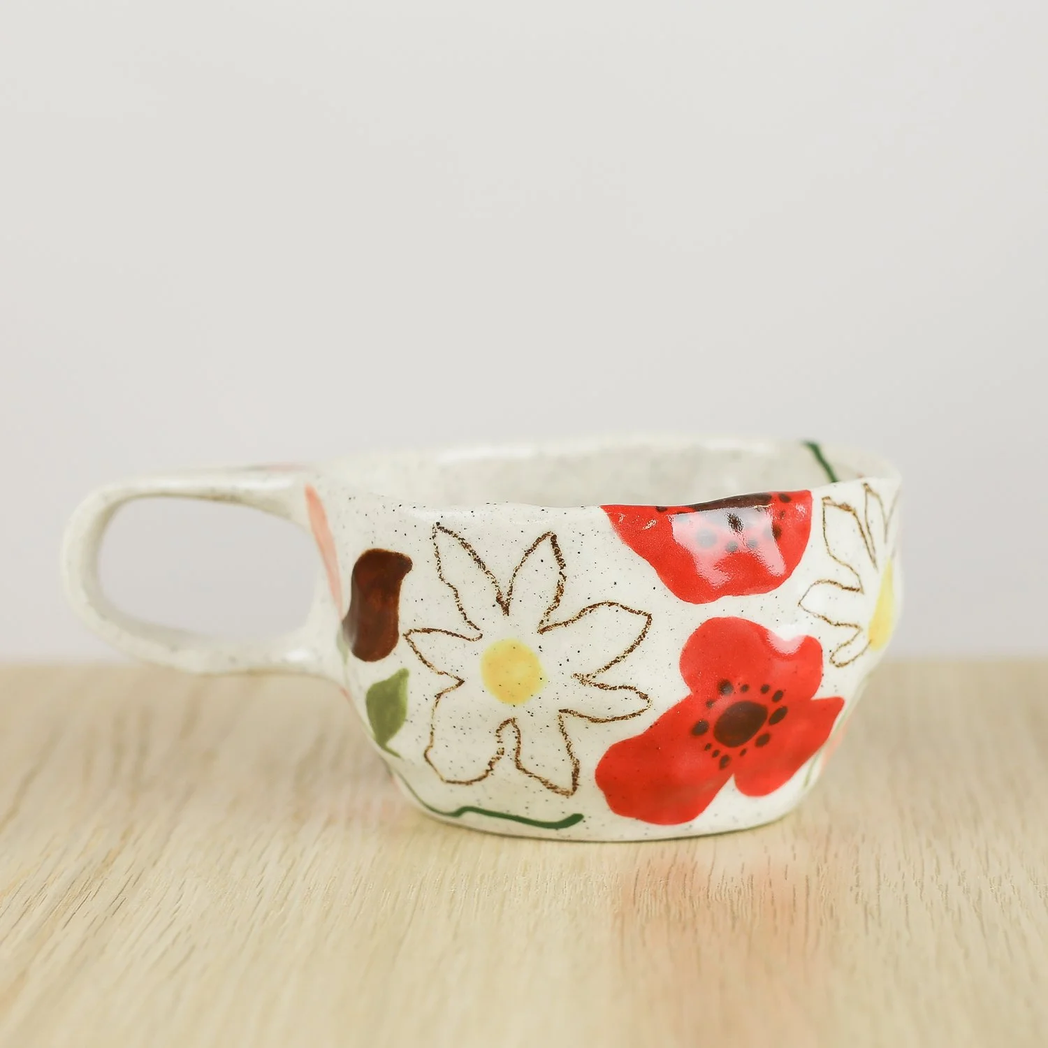 Handmade ceramic cup with hand-painted poppies, daisies and sweet pea flowers. Holds 150ml. A unique floral coffee cup for everyday rituals.