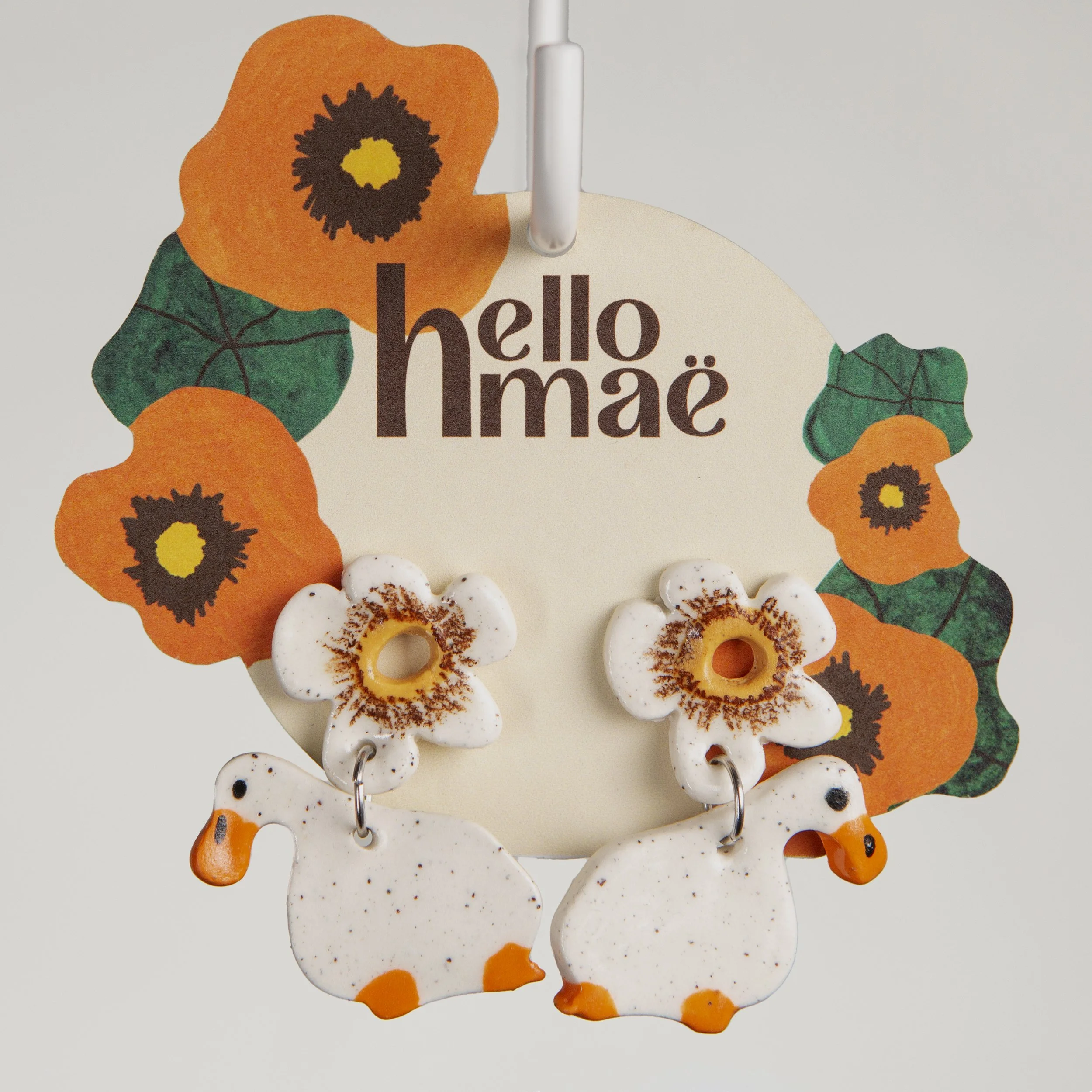 Handmade 2-tier ceramic white flower & white ducks earrings with surgical steel hooks photographed on a neutral background. (Copy) (Copy)