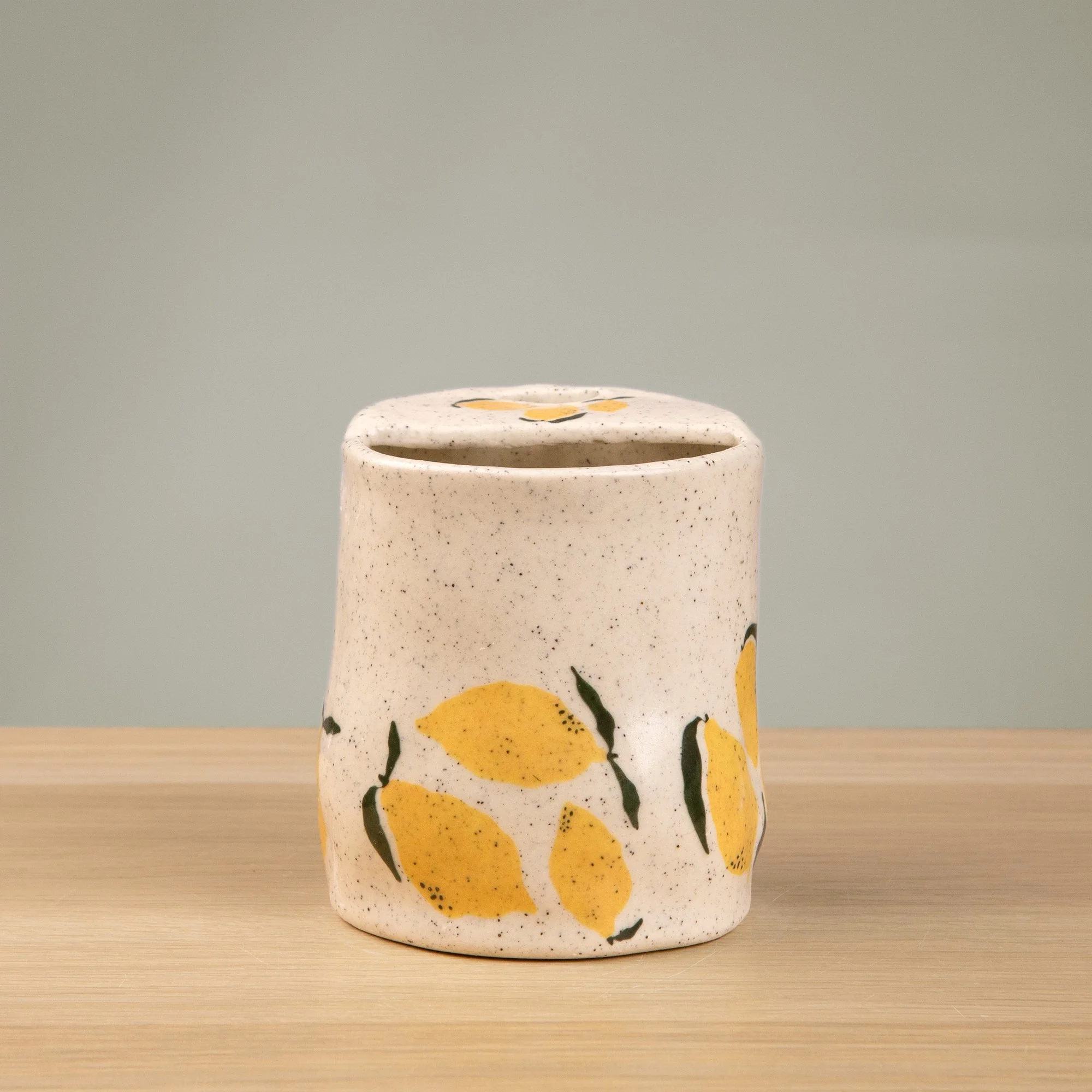 Handmade speckled ceramic lemon travel cup decorated with sweet lemon illustrations