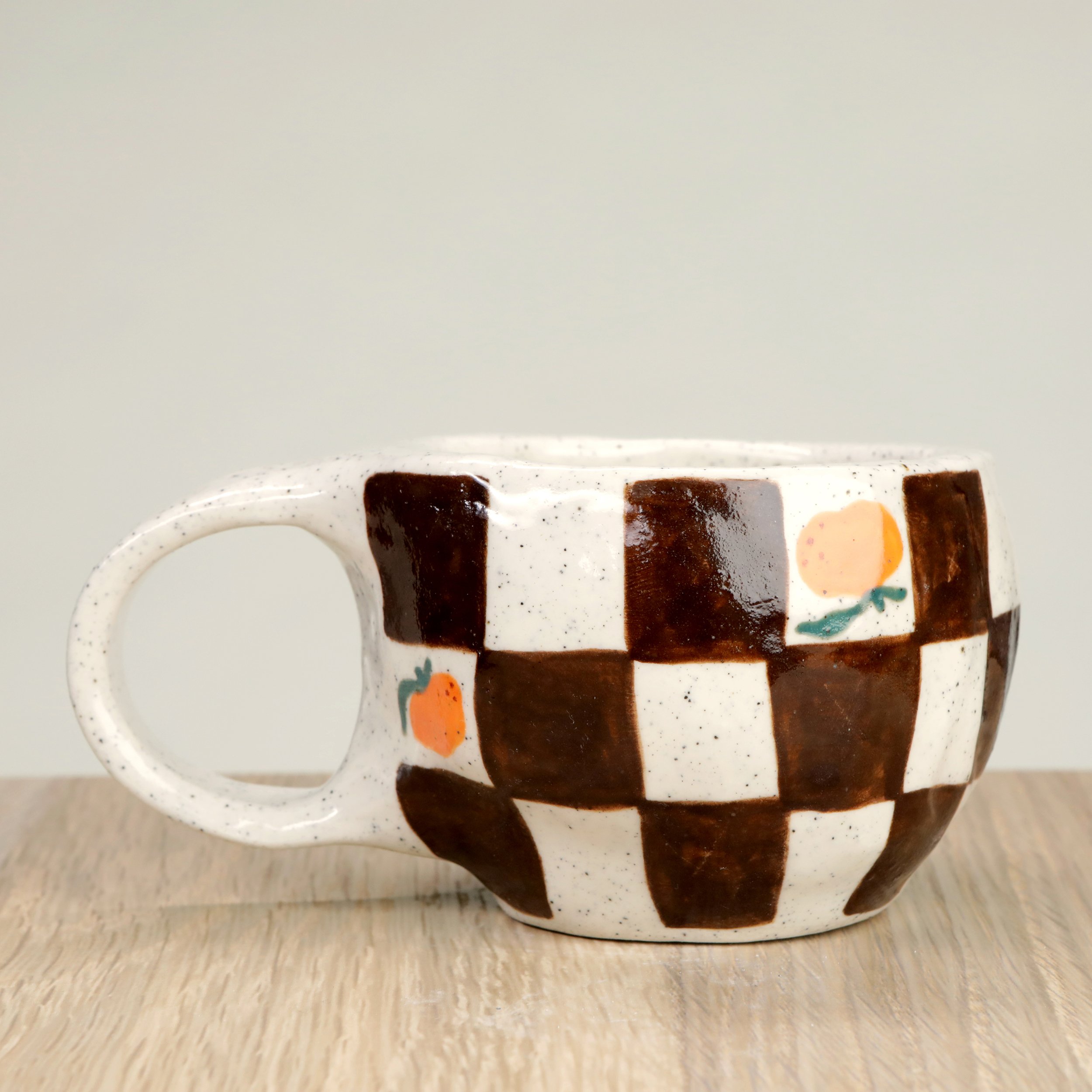 Handmade ceramic coffee cup with hand-painted Mandarins & a chocolate check, crafted from speckled clay in Melbourne. Holds approximately 150ml.