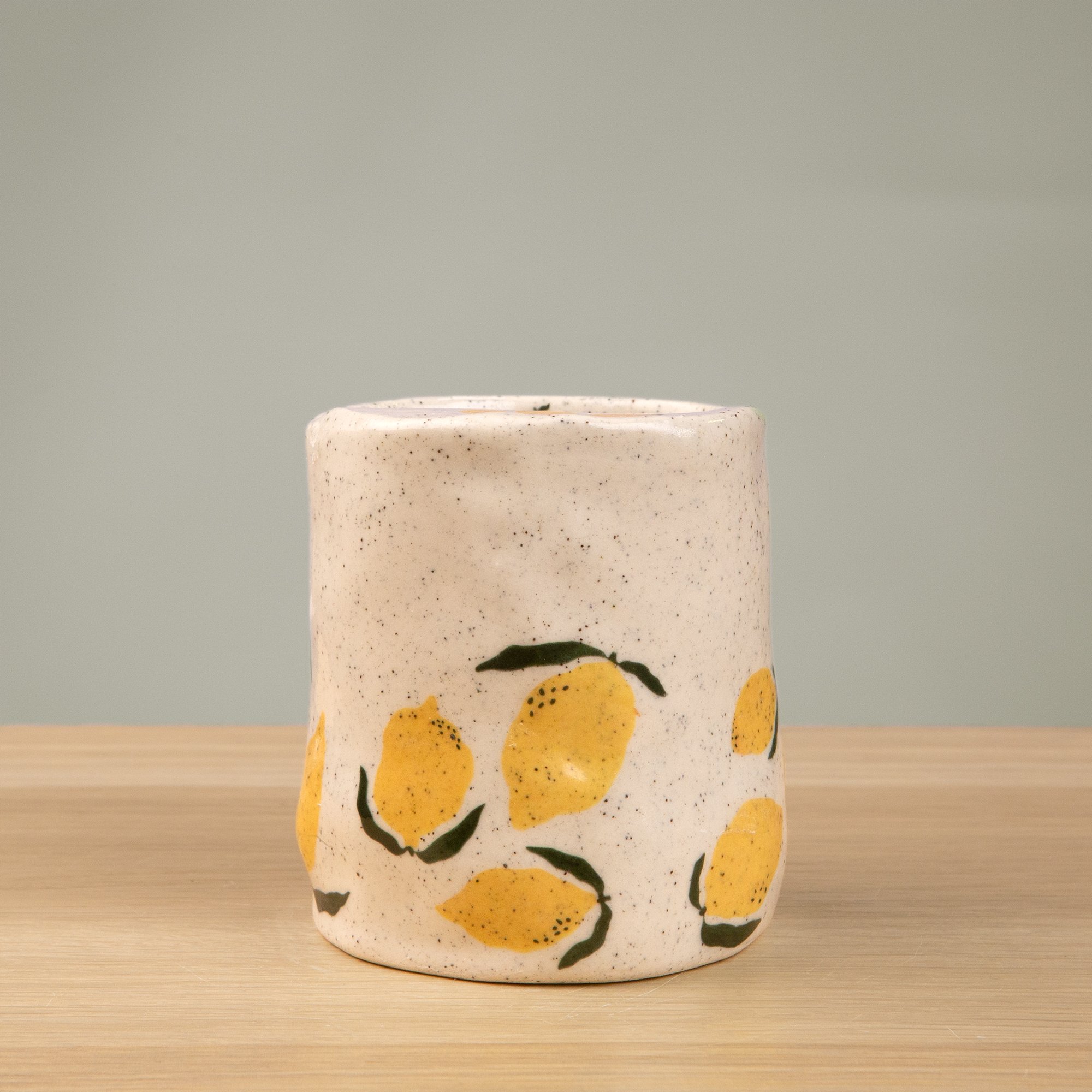 Handmade speckled ceramic lemon travel cup decorated with sweet lemon illustrations
