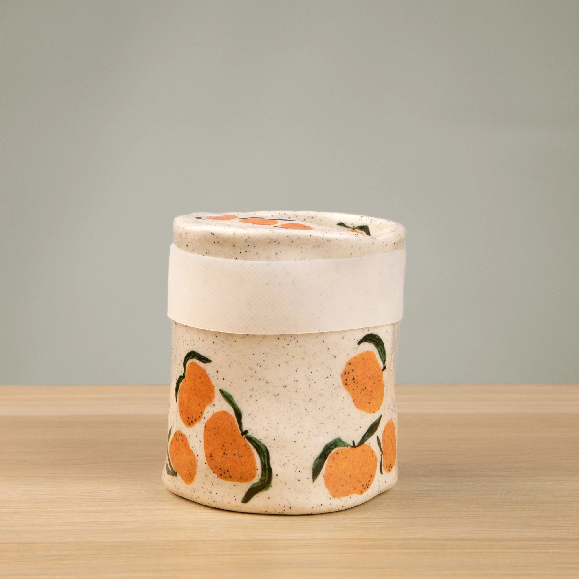 Handmade speckled ceramic mandarin travel cup decorated with sweet mandarin illustrations